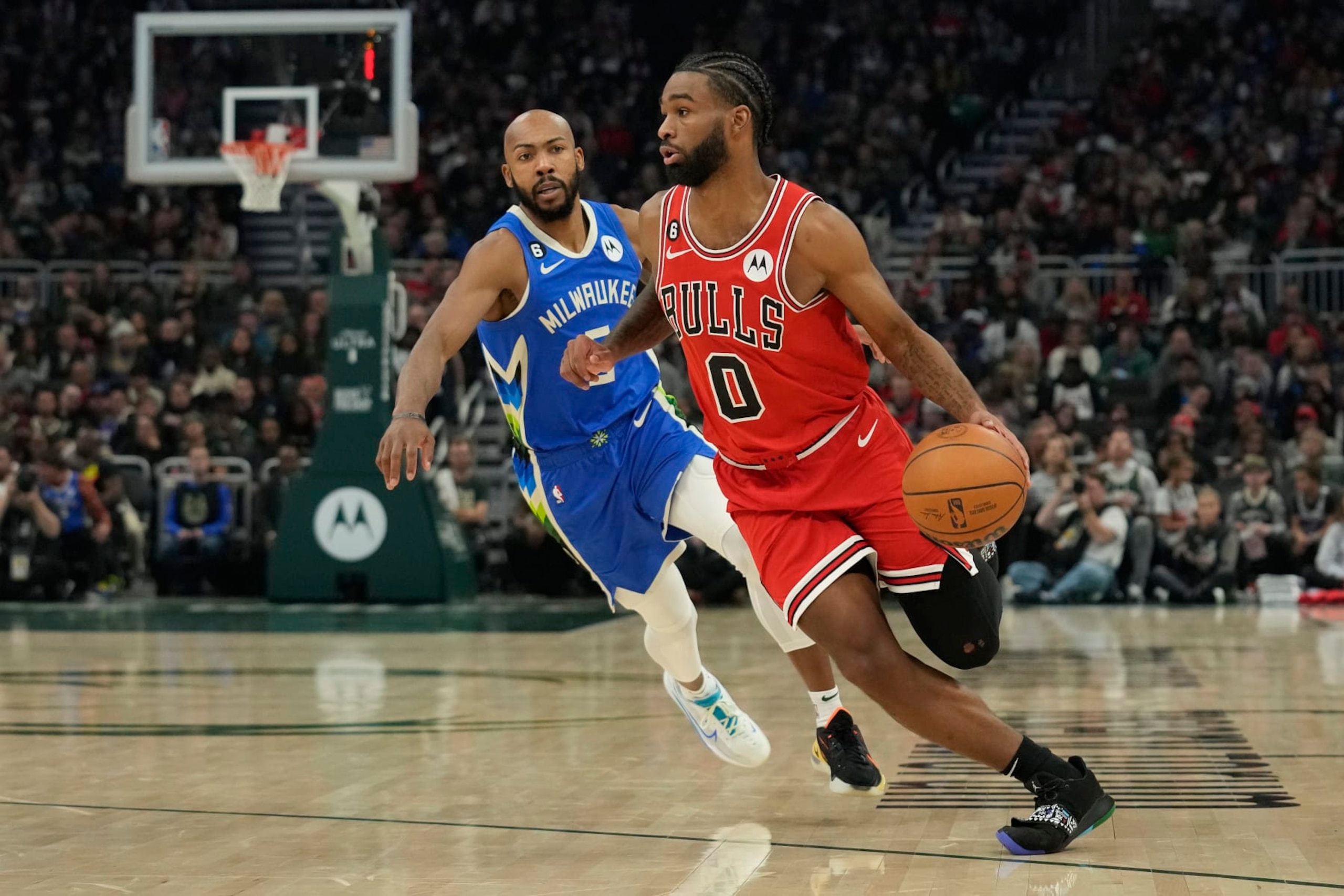 MILWAUKEE, WISCONSIN - NOVEMBER 23: Coby White #0 of the Chicago Bulls dribbles the ball against Jevon Carter #5 of the Milwaukee Bucks during the first half at Fiserv Forum on November 23, 2022 in Milwaukee, Wisconsin. NOTE TO USER: User expressly acknowledges and agrees that, by downloading and or using this photograph, User is consenting to the terms and conditions of the Getty Images License Agreement. (Photo by Patrick McDermott/Getty Images)