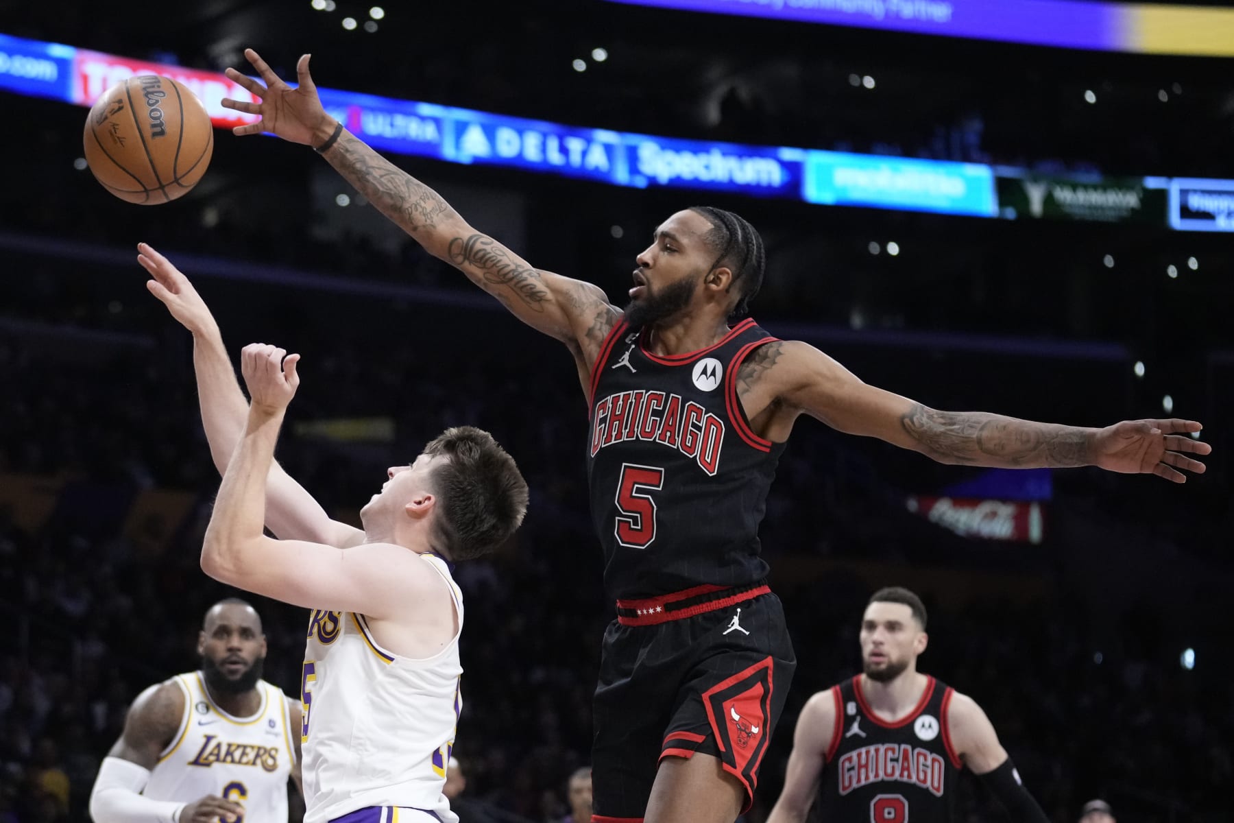 Chicago Bulls forward Derrick Jones Jr. (5) defends on Los Angeles Lakers guard Austin Reaves during the second half of an NBA basketball game Sunday, March 26, 2023, in Los Angeles. (AP Photo/Marcio Jose Sanchez)