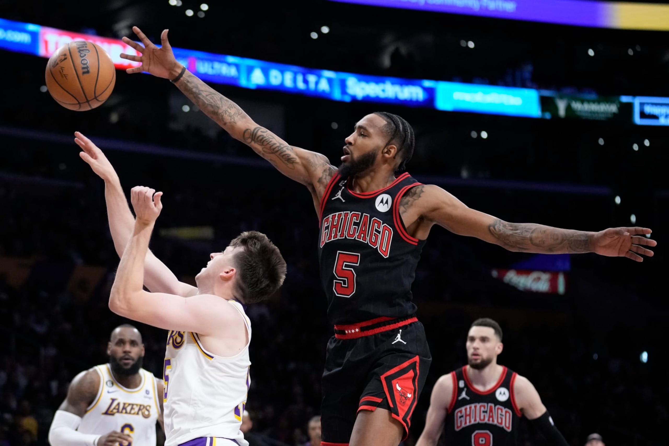 Chicago Bulls forward Derrick Jones Jr. (5) defends on Los Angeles Lakers guard Austin Reaves during the second half of an NBA basketball game Sunday, March 26, 2023, in Los Angeles. (AP Photo/Marcio Jose Sanchez)