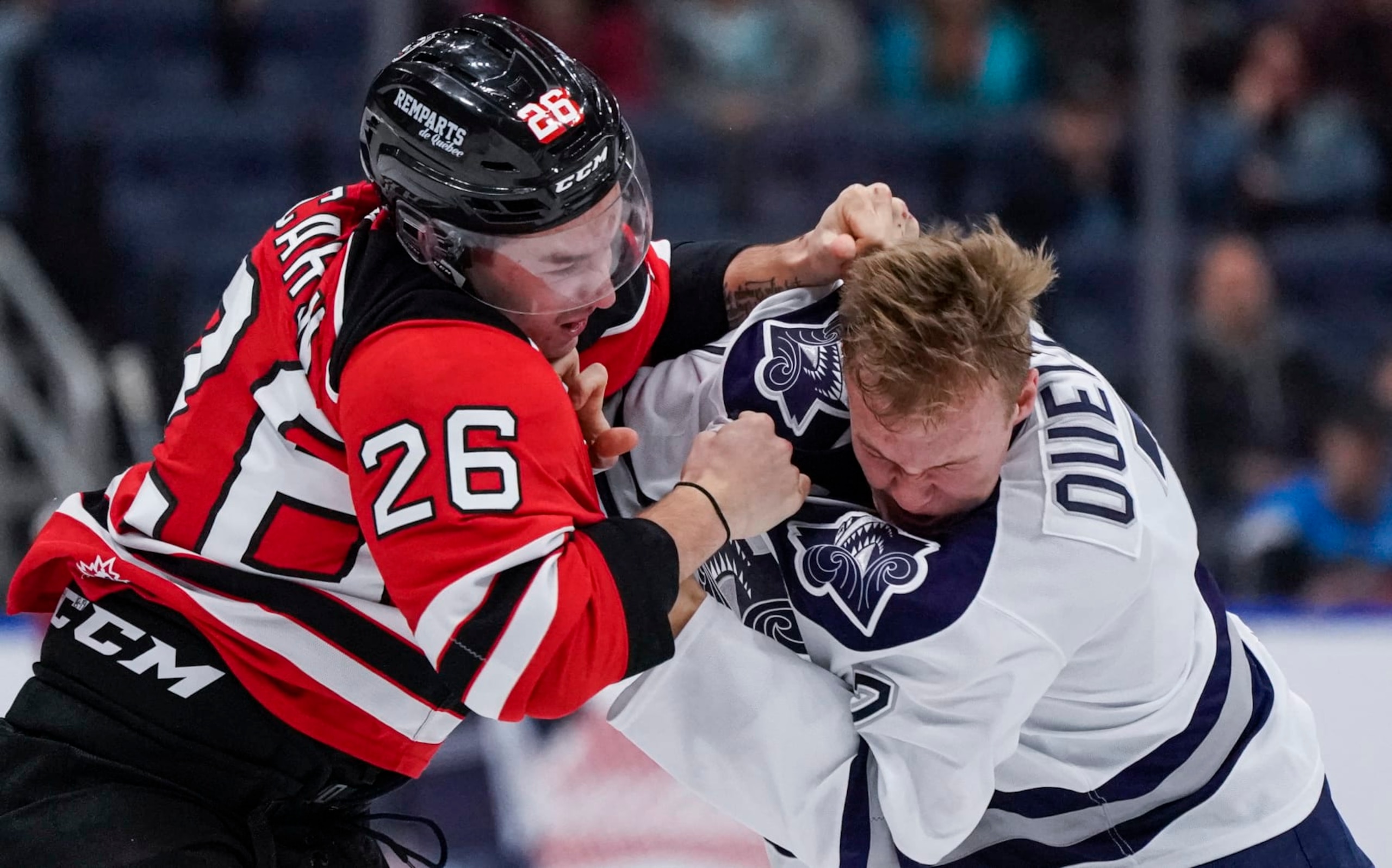 QUEBEC CITY, QC - OCTOBER 18:  Nathan Ouellet #7 of the Rimouski Oceanic and Thomas Caron #26 of the Quebec Remparts fight during their QMJHL hockey game at the Videotron Center on October 18, 2019 in Quebec City, Quebec, Canada. (Photo by Mathieu Belanger/Getty Images)
