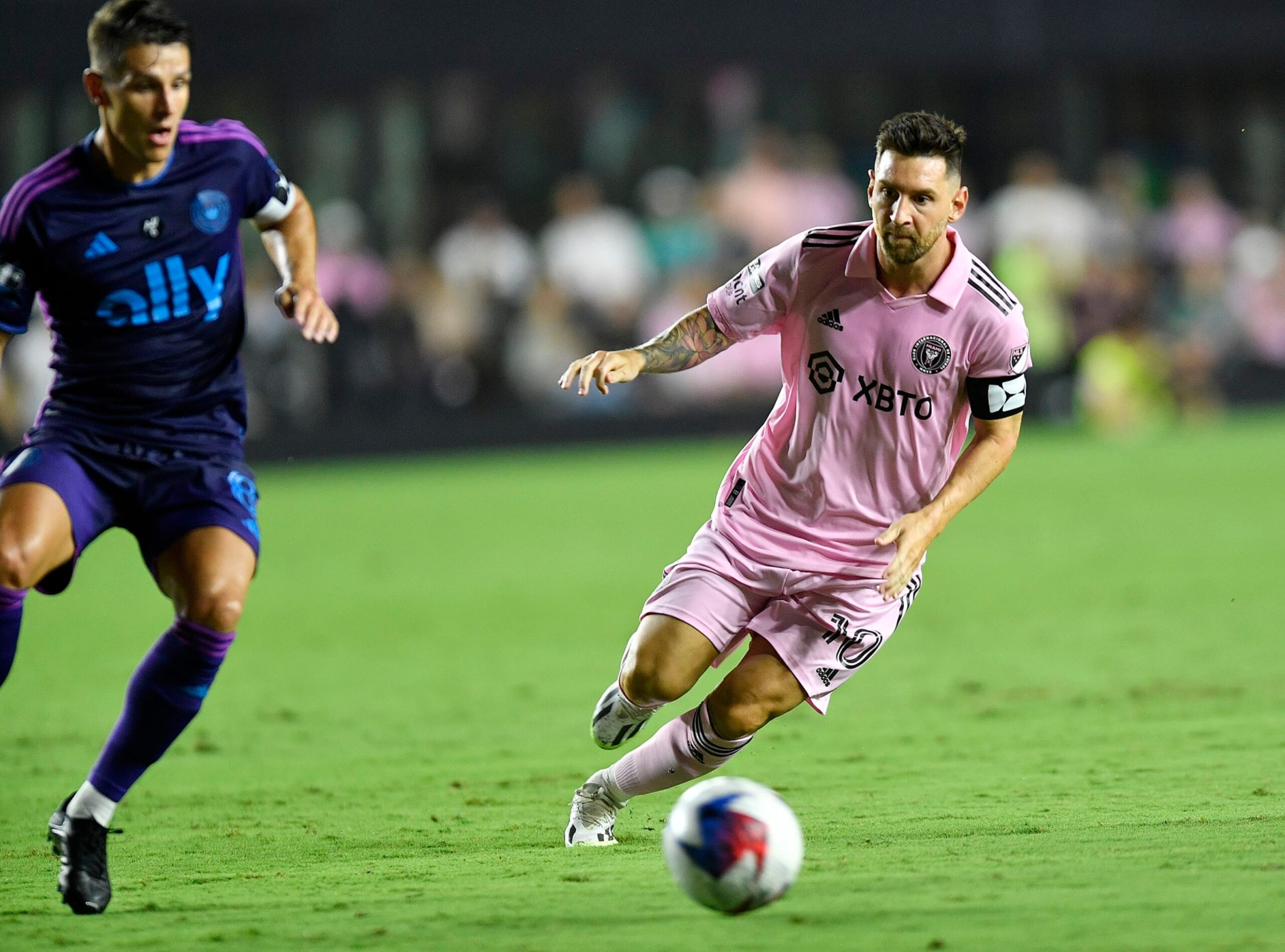 Inter Miami forward Lionel Messi, right, dribbles the ball in front of Charlotte FC midfielder Ashley Westwood during the first half of a Leagues Cup soccer match Friday, Aug. 11, 2023, in Fort Lauderdale, Fla. (AP Photo/Michael Laughlin)