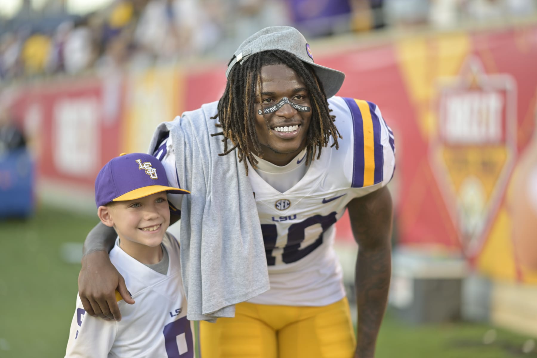ORLANDO, FL - JANUARY 02: LSU Tigers linebacker Harold Perkins Jr. (40) poses with a fan after the Cheez-It Citrus Bowl between the LSU Tigers and the Purdue Boilermakers on January 02, 2023 at Camping World Stadium in Orlando, FL. (Photo by Roy K. Miller/Icon Sportswire via Getty Images)