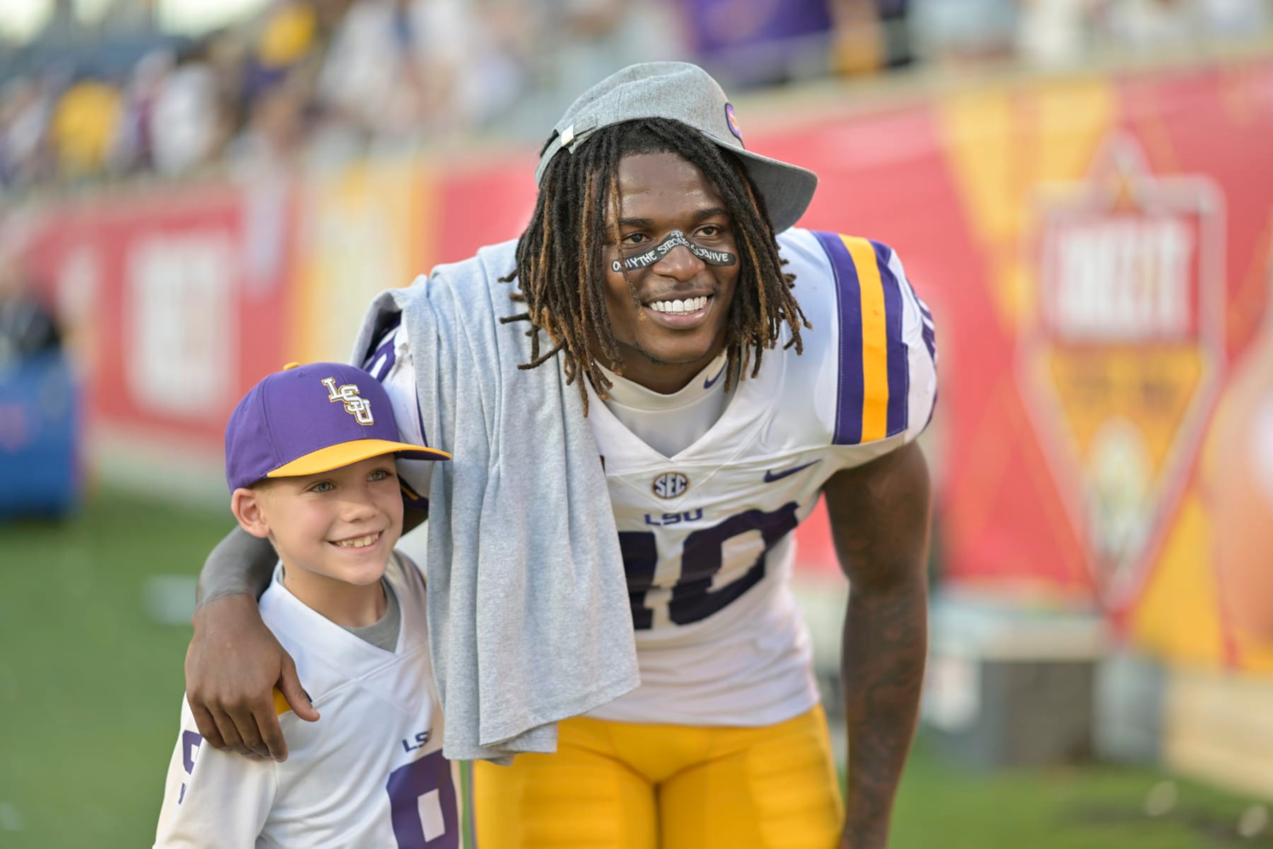 ORLANDO, FL - JANUARY 02: LSU Tigers linebacker Harold Perkins Jr. (40) poses with a fan after the Cheez-It Citrus Bowl between the LSU Tigers and the Purdue Boilermakers on January 02, 2023 at Camping World Stadium in Orlando, FL. (Photo by Roy K. Miller/Icon Sportswire via Getty Images)