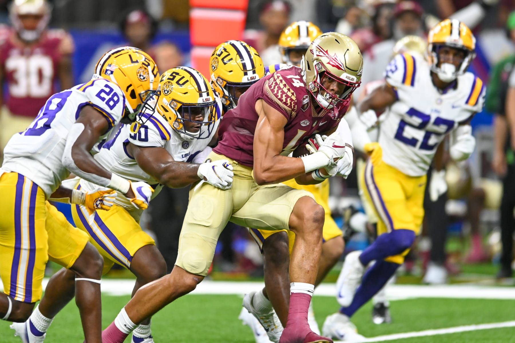 NEW ORLEANS, LA - SEPTEMBER 04: Florida State wide receiver Johnny Wilson (14) runs the ball as LSU linebacker Greg Penn III (30) tries to tackle him, during the Allstate Louisiana Kickoff game between the Florida State Seminoles and the LSU Tigers on September 04, 2022, at Caesars Superdome in New Orleans, LA. (Photo by Kevin Langley/Icon Sportswire via Getty Images)