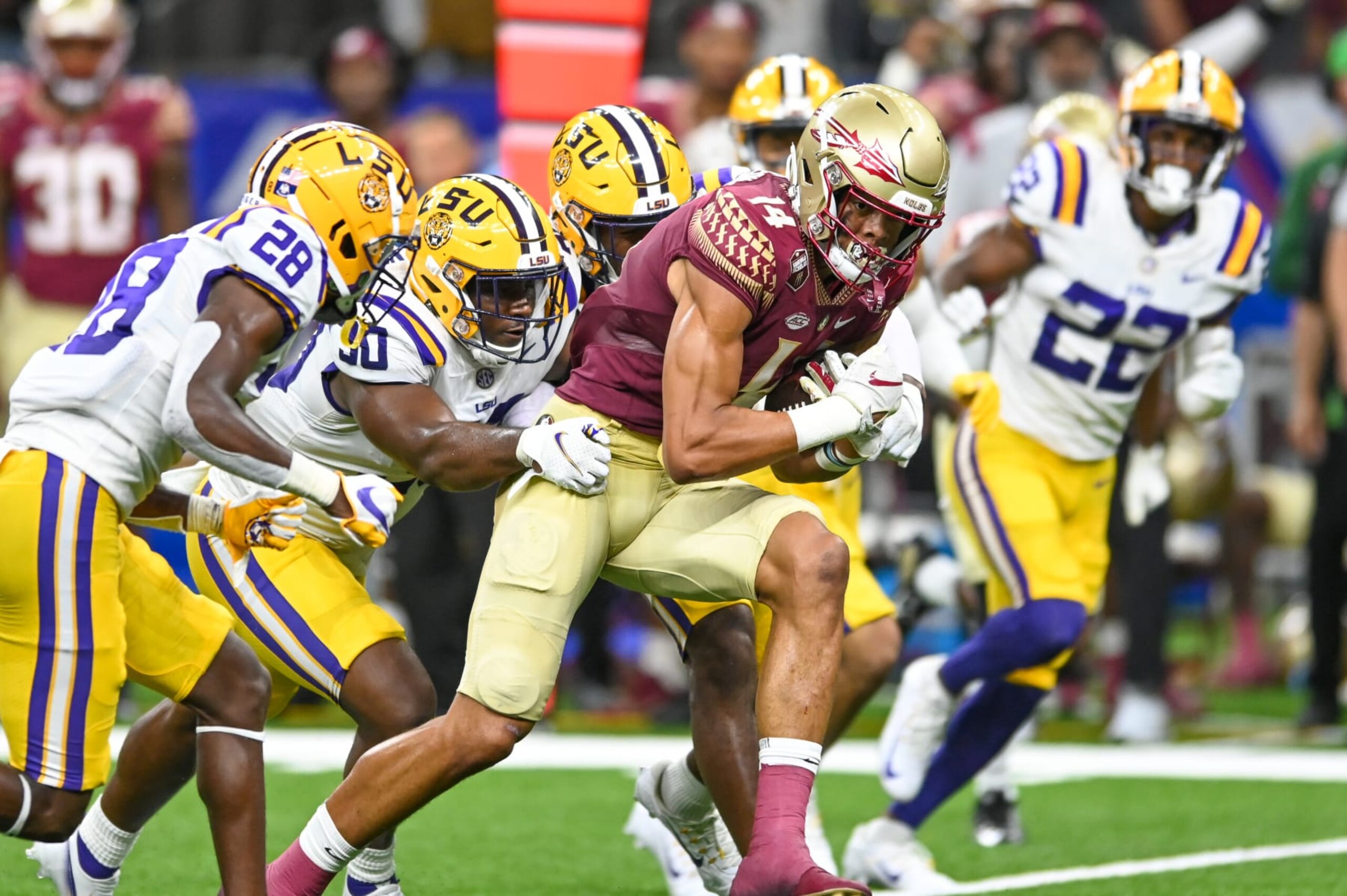 NEW ORLEANS, LA - SEPTEMBER 04: Florida State wide receiver Johnny Wilson (14) runs the ball as LSU linebacker Greg Penn III (30) tries to tackle him, during the Allstate Louisiana Kickoff game between the Florida State Seminoles and the LSU Tigers on September 04, 2022, at Caesars Superdome in New Orleans, LA. (Photo by Kevin Langley/Icon Sportswire via Getty Images)