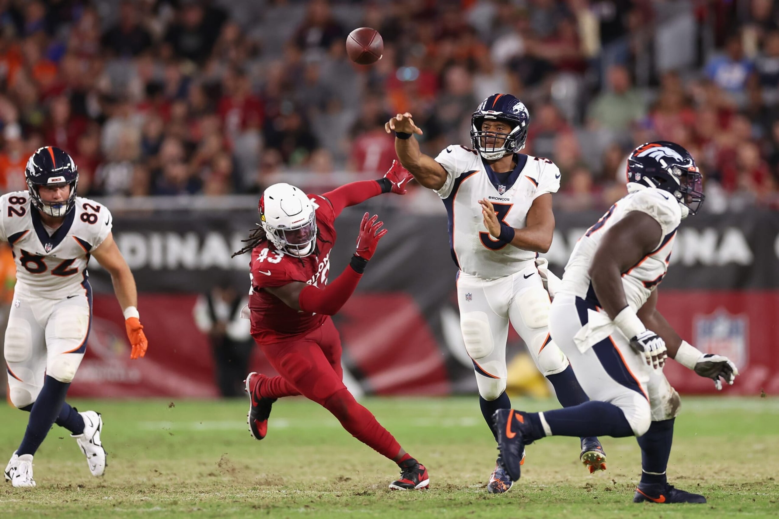 GLENDALE, ARIZONA - AUGUST 11: Quarterback Russell Wilson #3 of the Denver Broncos throws a pass under pressure from linebacker Jesse Luketa #43 of the Arizona Cardinals during the first half of the NFL game at State Farm Stadium on August 11, 2023 in Glendale, Arizona. (Photo by Christian Petersen/Getty Images) GLENDALE, ARIZONA - AUGUST 11: Quarterback Russell Wilson #3 of the Denver Broncos throws a pass under pressure from linebacker Jesse Luketa #43 of the Arizona Cardinals during the first half of the NFL game at State Farm Stadium on August 11, 2023 in Glendale, Arizona. (Photo by Christian Petersen/Getty Images)
