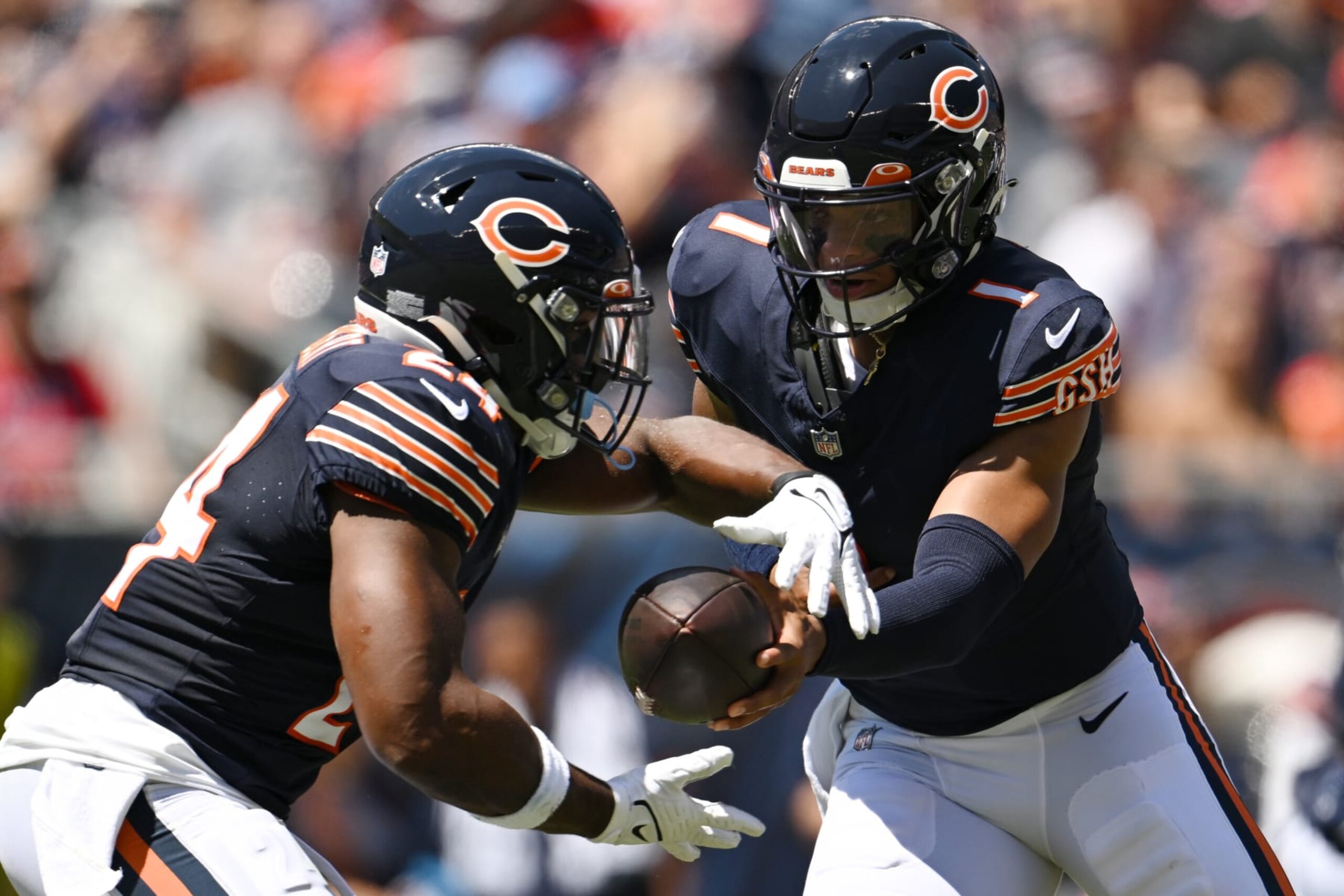 CHICAGO, ILLINOIS - AUGUST 12: Justin Fields #1 hands the football to Khalil Herbert #24 of the Chicago Bears in the first half against the Tennessee Titans during a preseason game at Soldier Field on August 12, 2023 in Chicago, Illinois. (Photo by Quinn Harris/Getty Images)