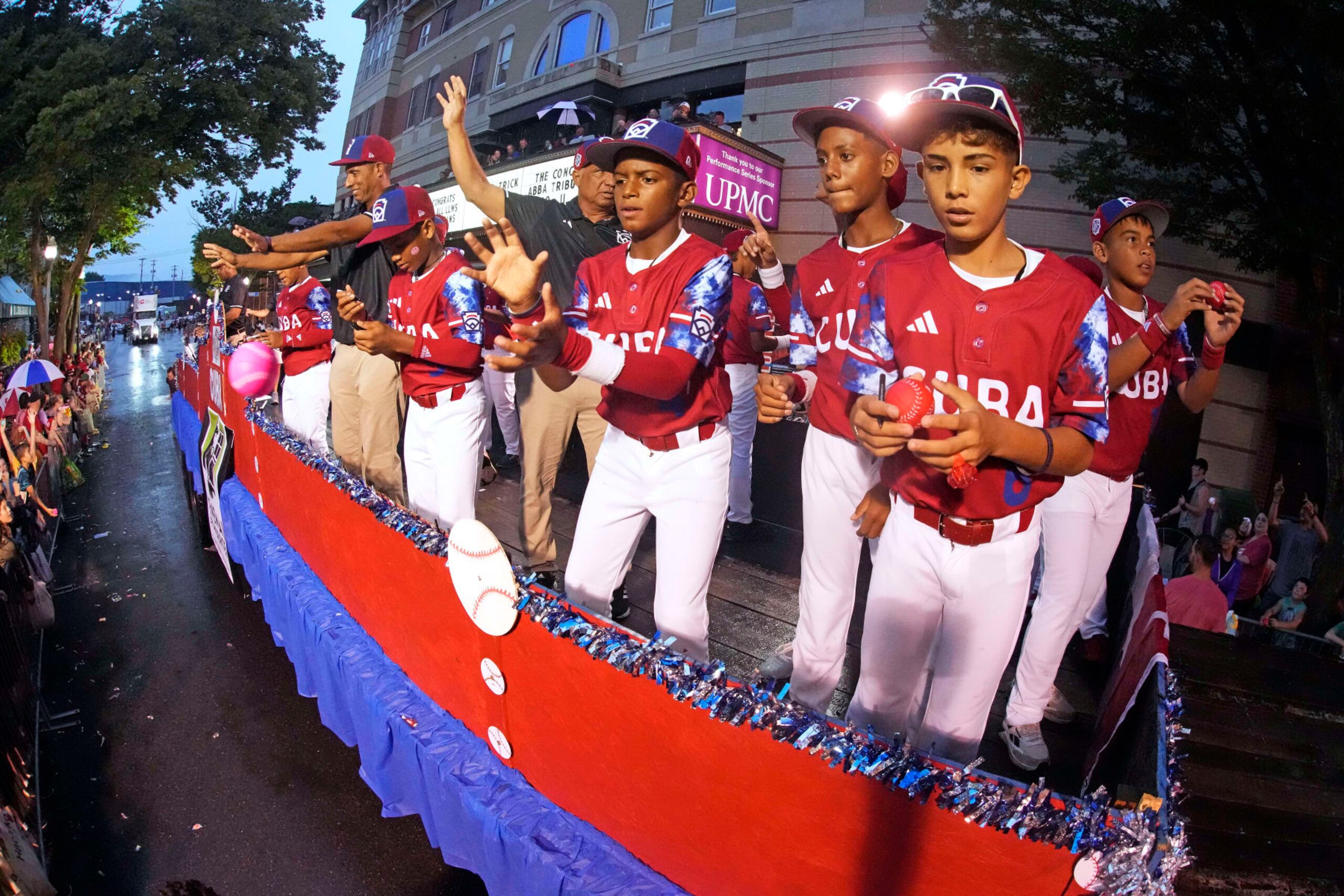 The Cuba Region champion Little League team from Bayamo, Cuba, rides in the Little League Grand Slam Parade in downtown Williamsport, Pa., Monday, Aug. 14, 2023. The Little League World Series baseball tournament, featuring 20 teams from around the world, starts later in week in South Williamsport, Pa. (AP Photo/Gene J. Puskar)
