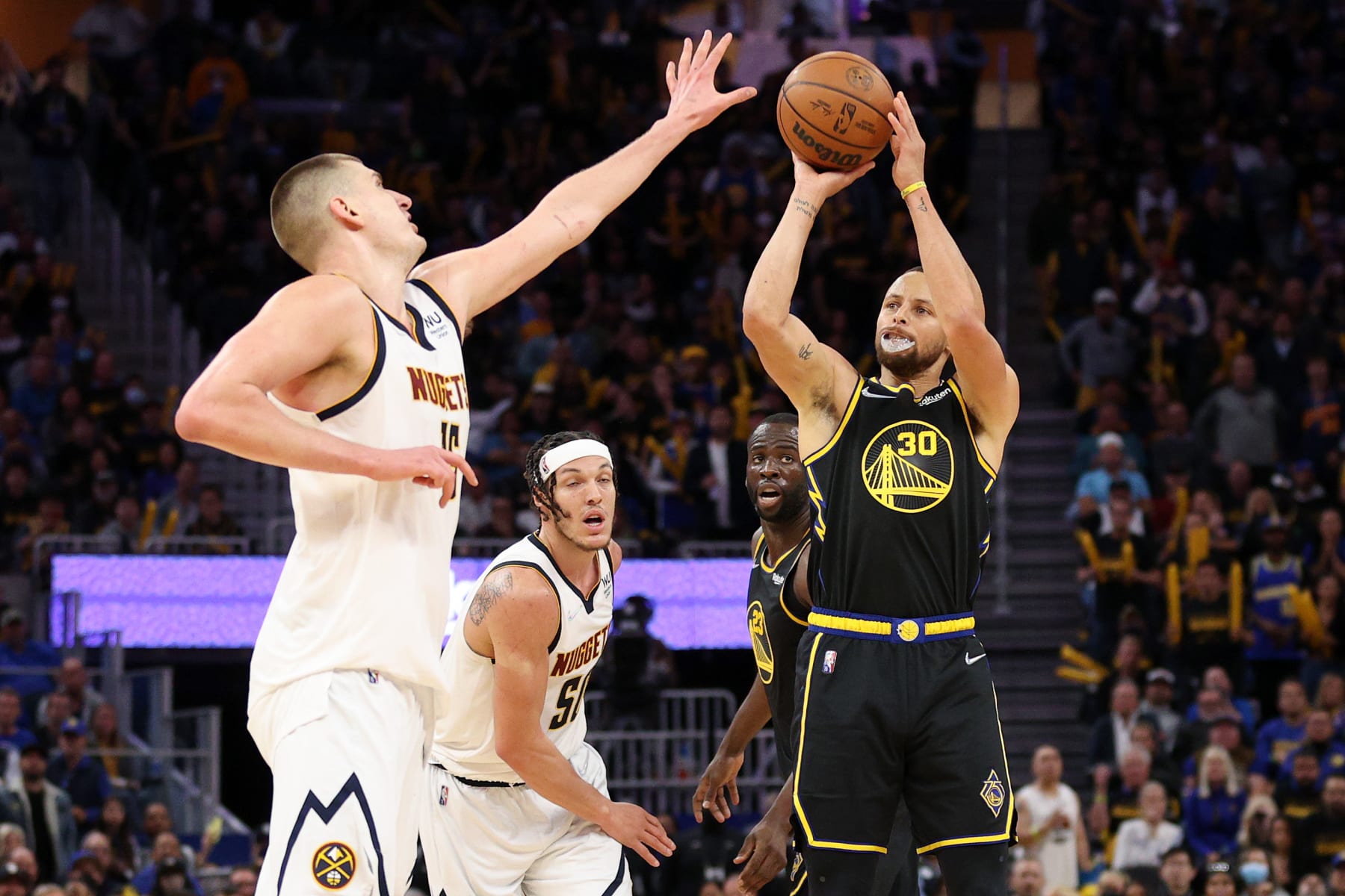 SAN FRANCISCO, CALIFORNIA - APRIL 27:  Stephen Curry #30 of the Golden State Warriors shoots over Nikola Jokic #15 of the Denver Nuggets in the second half during Game Five of the Western Conference First Round NBA Playoffs at Chase Center on April 27, 2022 in San Francisco, California. NOTE TO USER: User expressly acknowledges and agrees that, by downloading and/or using this photograph, User is consenting to the terms and conditions of the Getty Images License Agreement.  (Photo by Ezra Shaw/Getty Images)