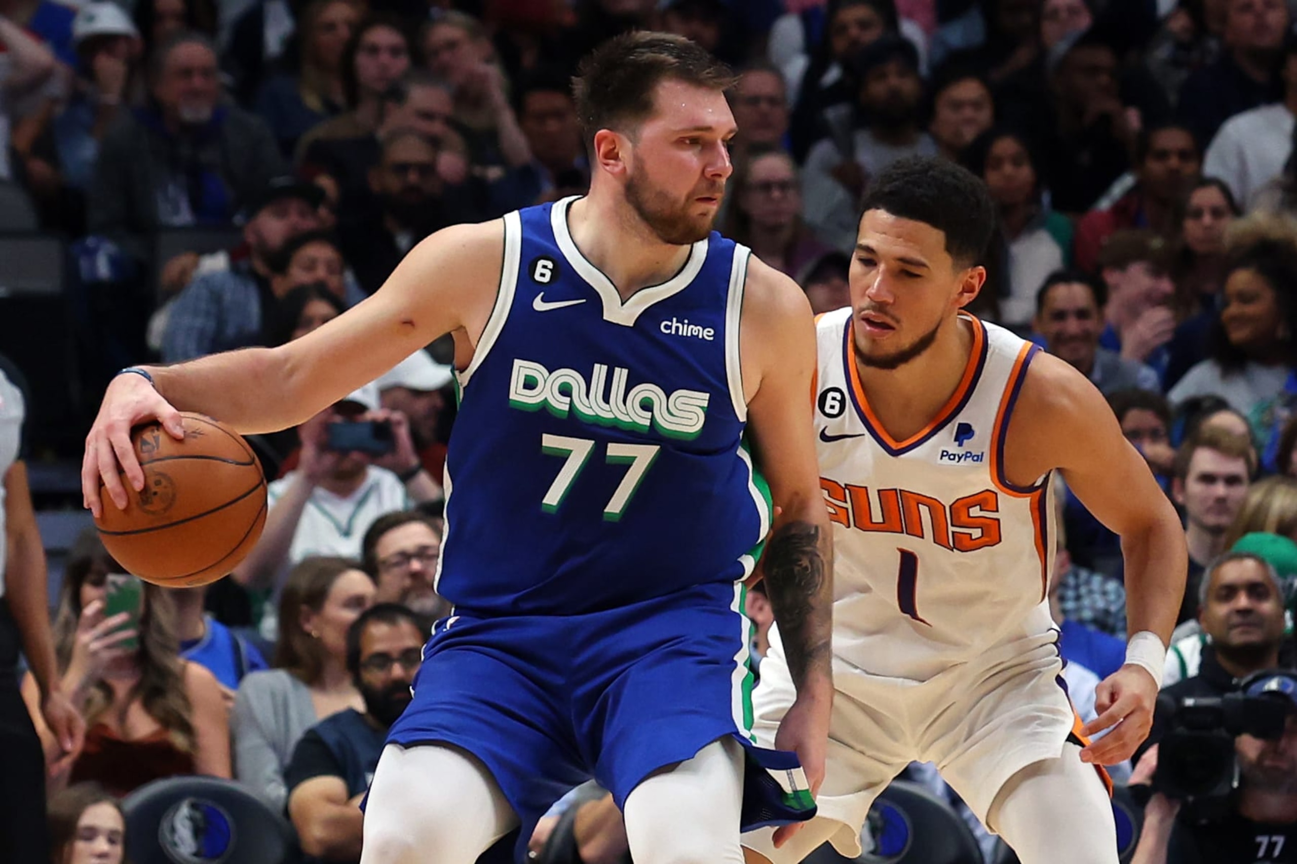 DALLAS, TEXAS - DECEMBER 05: Luka Doncic #77 of the Dallas Mavericks is guarded by Devin Booker #1 of the Phoenix Suns in the second half at American Airlines Center on December 05, 2022 in Dallas, Texas.  NOTE TO USER: User expressly acknowledges and agrees that, by downloading and/or using this Photograph, user is consenting to the terms and conditions of the Getty Images License Agreement. (Photo by Richard Rodriguez/Getty Images)