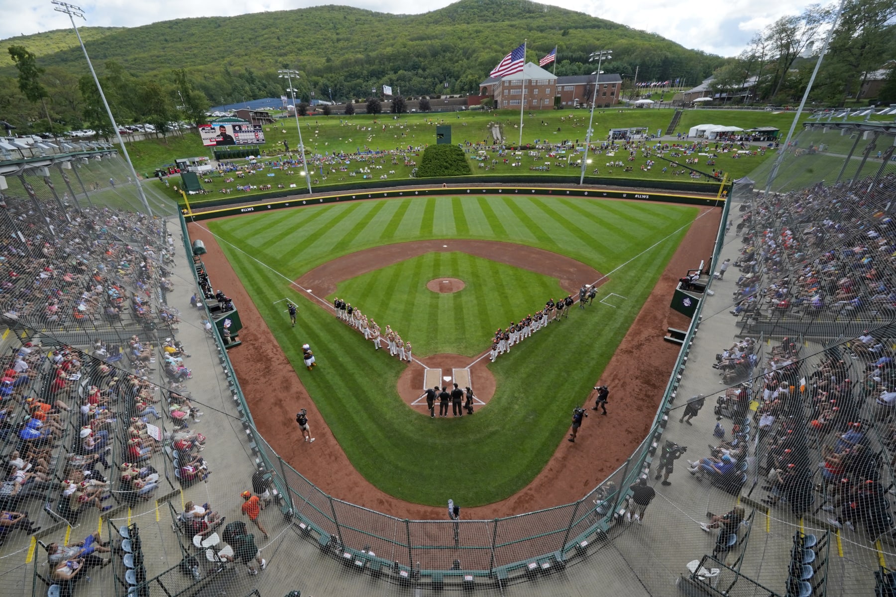 Henderson, Nev., lines the first baseline and Smithfield, R.I. lines the third baseline at Lamade Stadium during team introductions before a baseball game at the Little League World Series in South Williamsport, Pa., Wednesday, Aug. 16, 2023. (AP Photo/Gene J. Puskar)