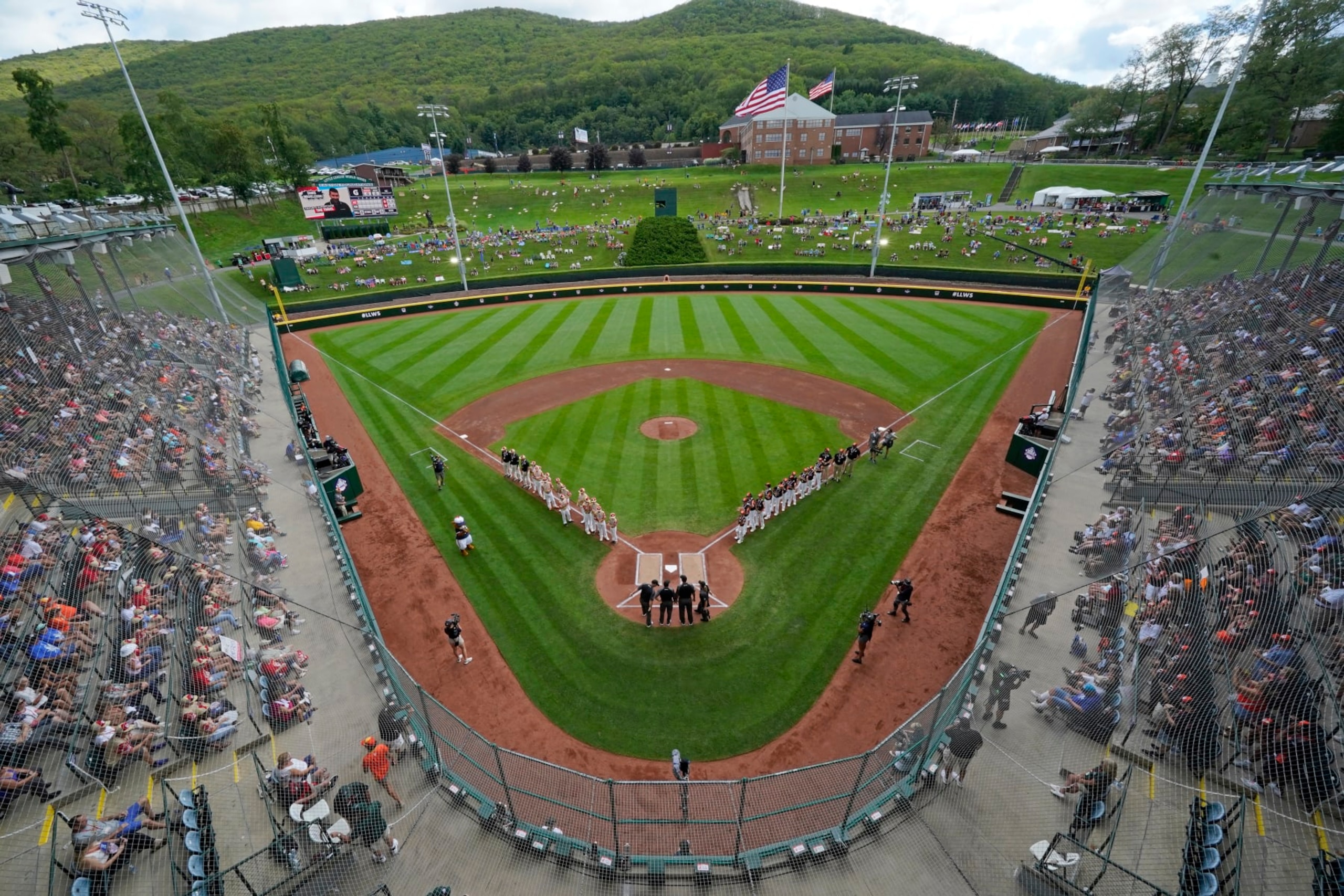 Henderson, Nev., lines the first baseline and Smithfield, R.I. lines the third baseline at Lamade Stadium during team introductions before a baseball game at the Little League World Series in South Williamsport, Pa., Wednesday, Aug. 16, 2023. (AP Photo/Gene J. Puskar)
