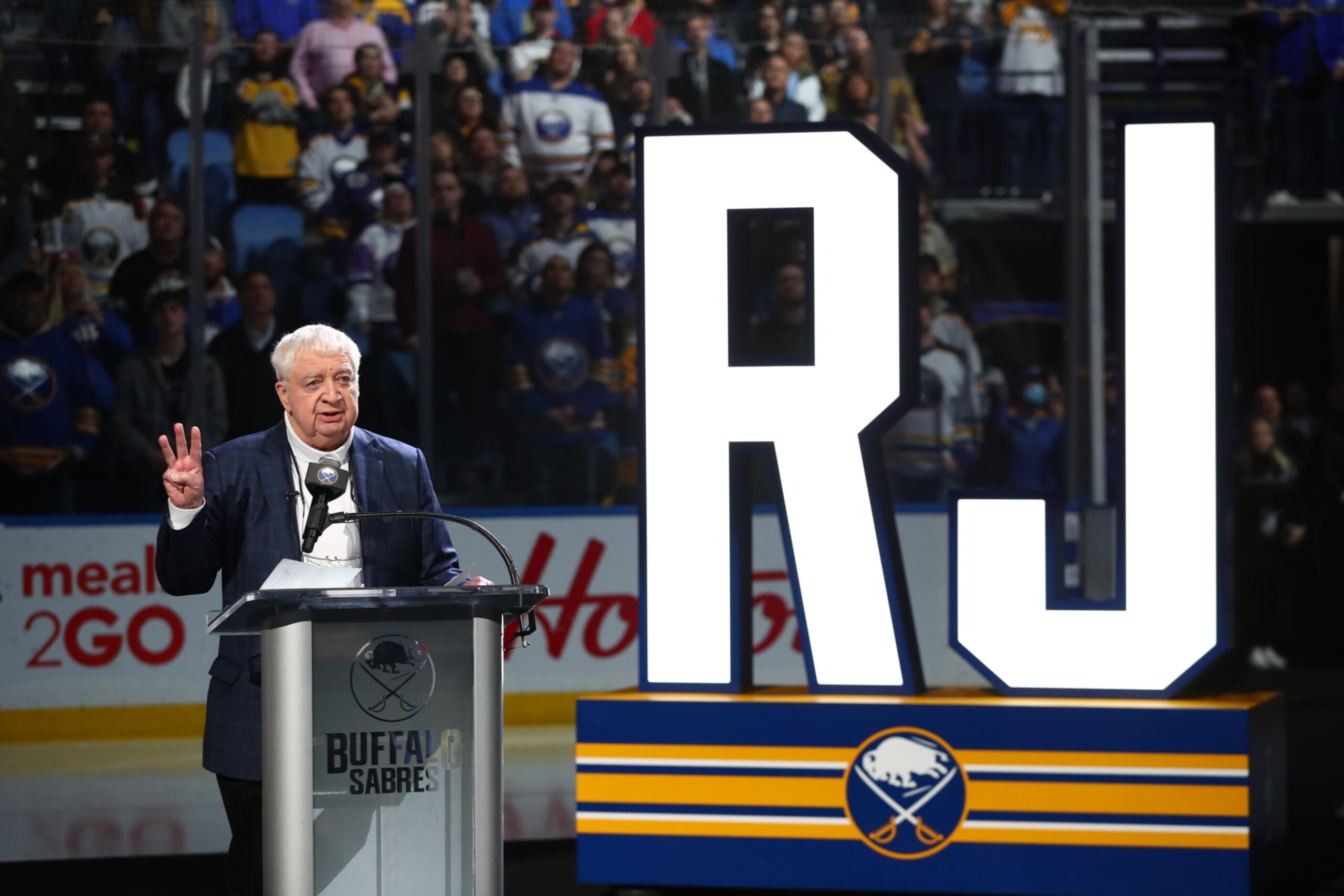 BUFFALO, NY - APRIL 1: Hall-of-Fame Buffalo Sabres play-by-play announcer Rick Jeanneret speaks as a banner bearing his name is added to the rafters of KeyBank Center in a ceremony prior to an NHL game against the Nashville Predators on April 1, 2022 at KeyBank Center in Buffalo, New York. (Photo by Bill Wippert/NHLI via Getty Images) BUFFALO, NY - APRIL 1: Hall-of-Fame Buffalo Sabres play-by-play announcer Rick Jeanneret speaks as a banner bearing his name is added to the rafters of KeyBank Center in a ceremony prior to an NHL game against the Nashville Predators on April 1, 2022 at KeyBank Center in Buffalo, New York. (Photo by Bill Wippert/NHLI via Getty Images)