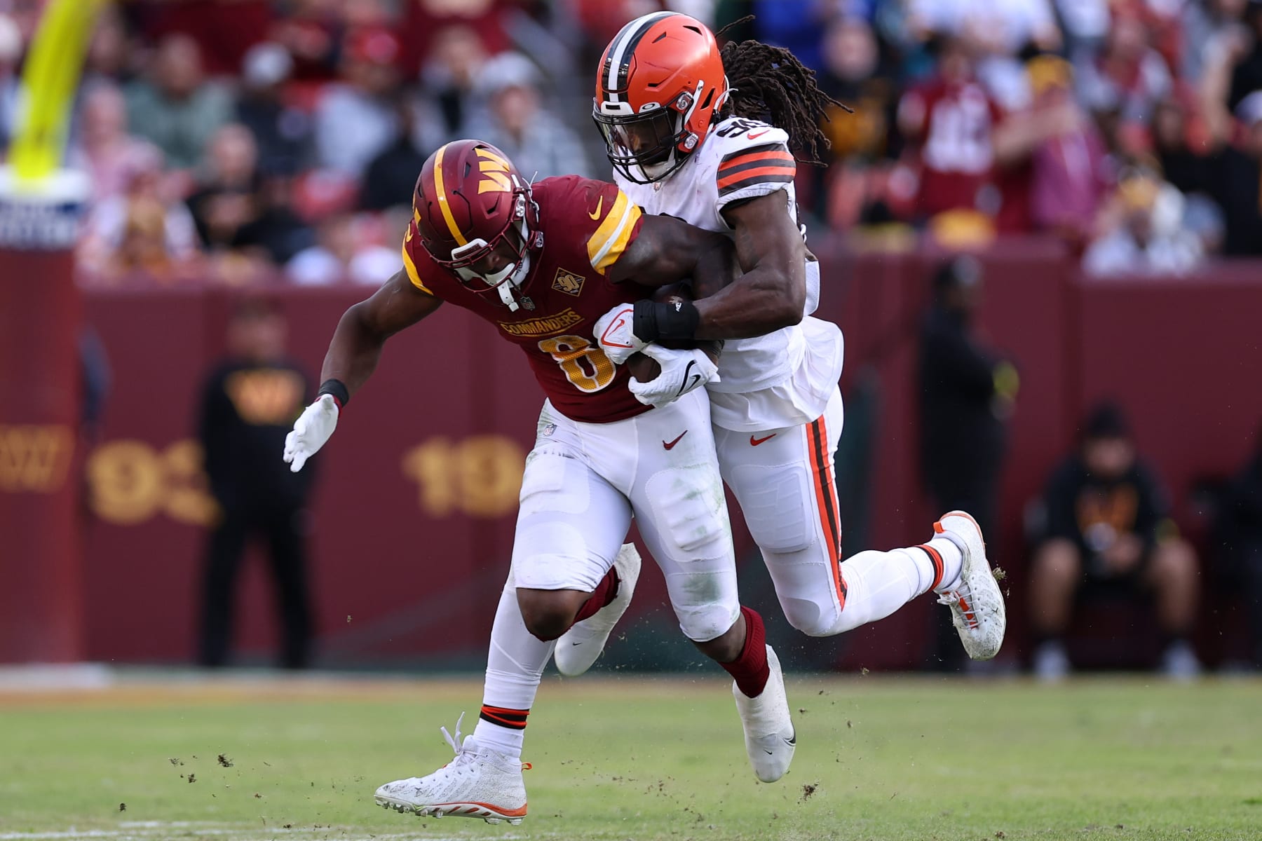 LANDOVER, MARYLAND - JANUARY 01: Brian Robinson Jr. #8 of the Washington Commanders is tackled by Jadeveon Clowney #90 of the Cleveland Browns during the third quarter at FedExField on January 01, 2023 in Landover, Maryland. (Photo by Scott Taetsch/Getty Images)