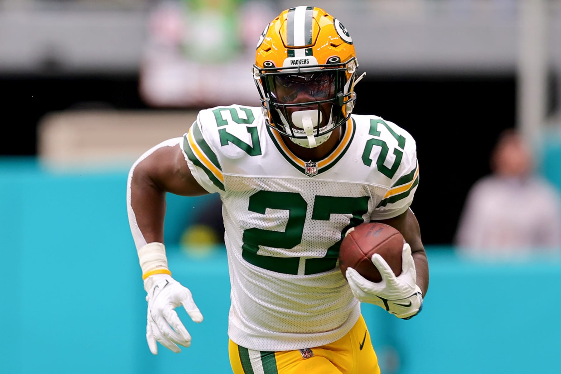 MIAMI GARDENS, FLORIDA - DECEMBER 25: Patrick Taylor #27 of the Green Bay Packers carries the ball against the Miami Dolphins during the second half of the game at Hard Rock Stadium on December 25, 2022 in Miami Gardens, Florida. (Photo by Megan Briggs/Getty Images)