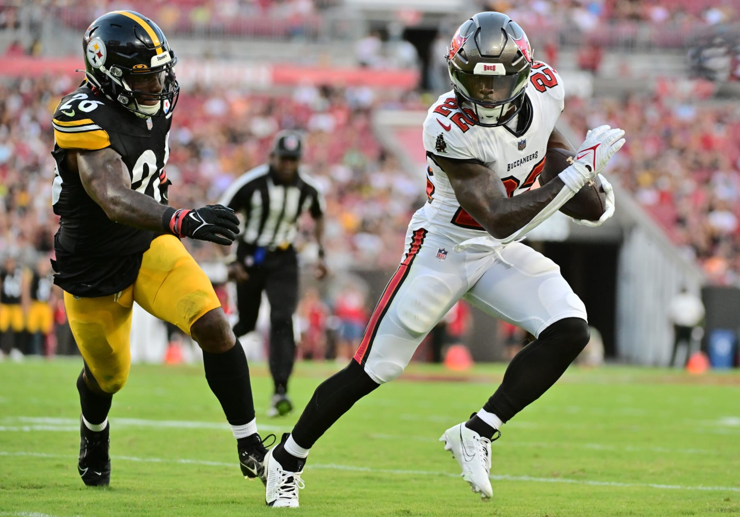 TAMPA, FLORIDA - AUGUST 11: Chase Edmonds #22 of the Tampa Bay Buccaneers runs the ball against Kwon Alexander #26 of the Pittsburgh Steelers in the second quarter during a preseason game at Raymond James Stadium on August 11, 2023 in Tampa, Florida. (Photo by Julio Aguilar/Getty Images)