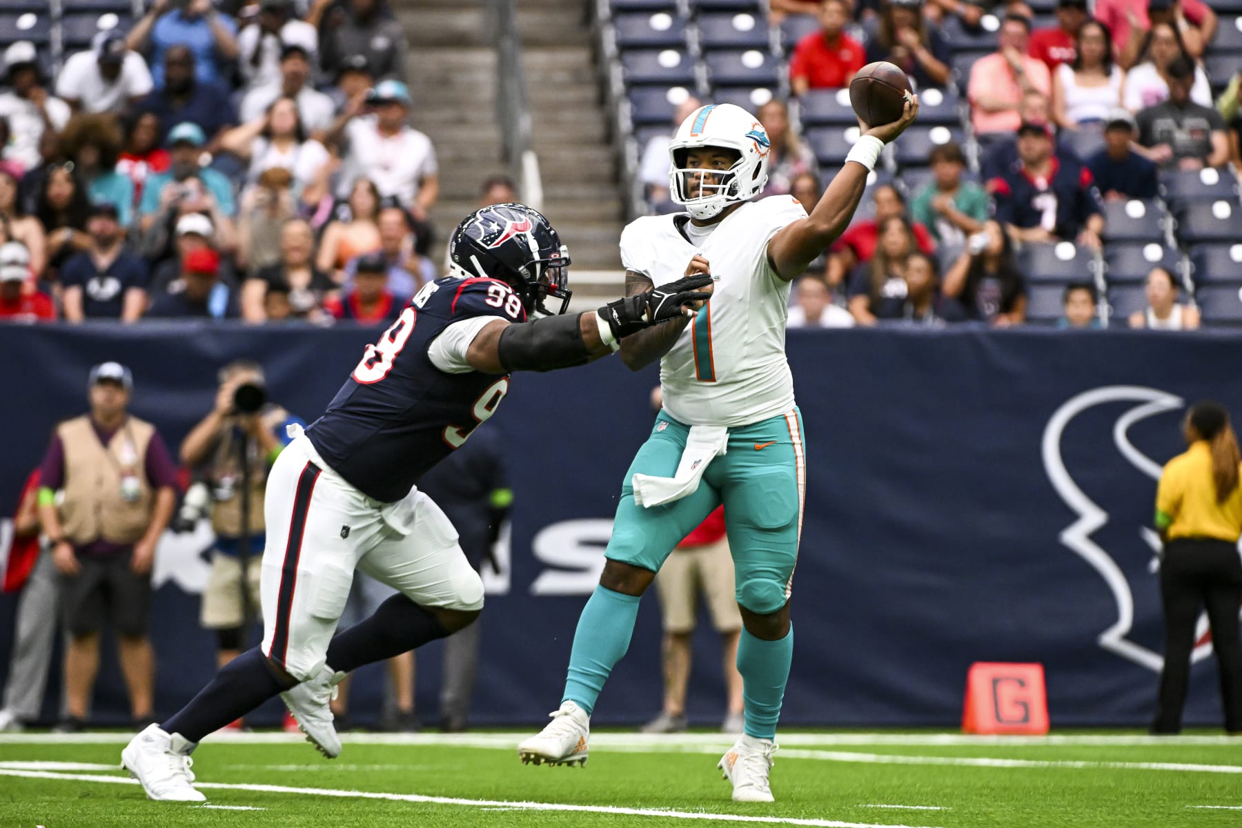 HOUSTON, TEXAS - AUGUST 19: Tua Tagovailoa #1 of the Miami Dolphins passes the ball under pressure by Sheldon Rankins #98 of the Houston Texans during the preseason game at NRG Stadium on August 19, 2023 in Houston, Texas. (Photo by Logan Riely/Getty Images)