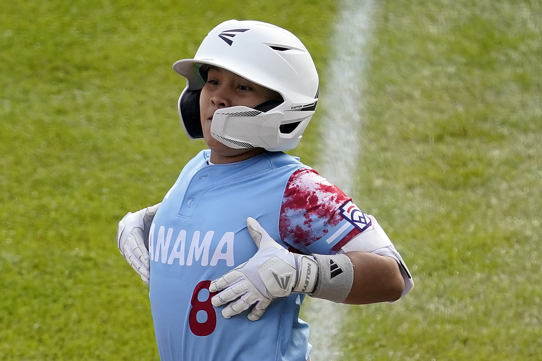 Panama's Ian Corrales (8) celebrates on first base after driving in a run against Cuba during the first inning of a baseball game at the Little League World Series tournament in South Williamsport, Pa., Sunday, Aug. 20, 2023. (AP Photo/Tom E. Puskar)
