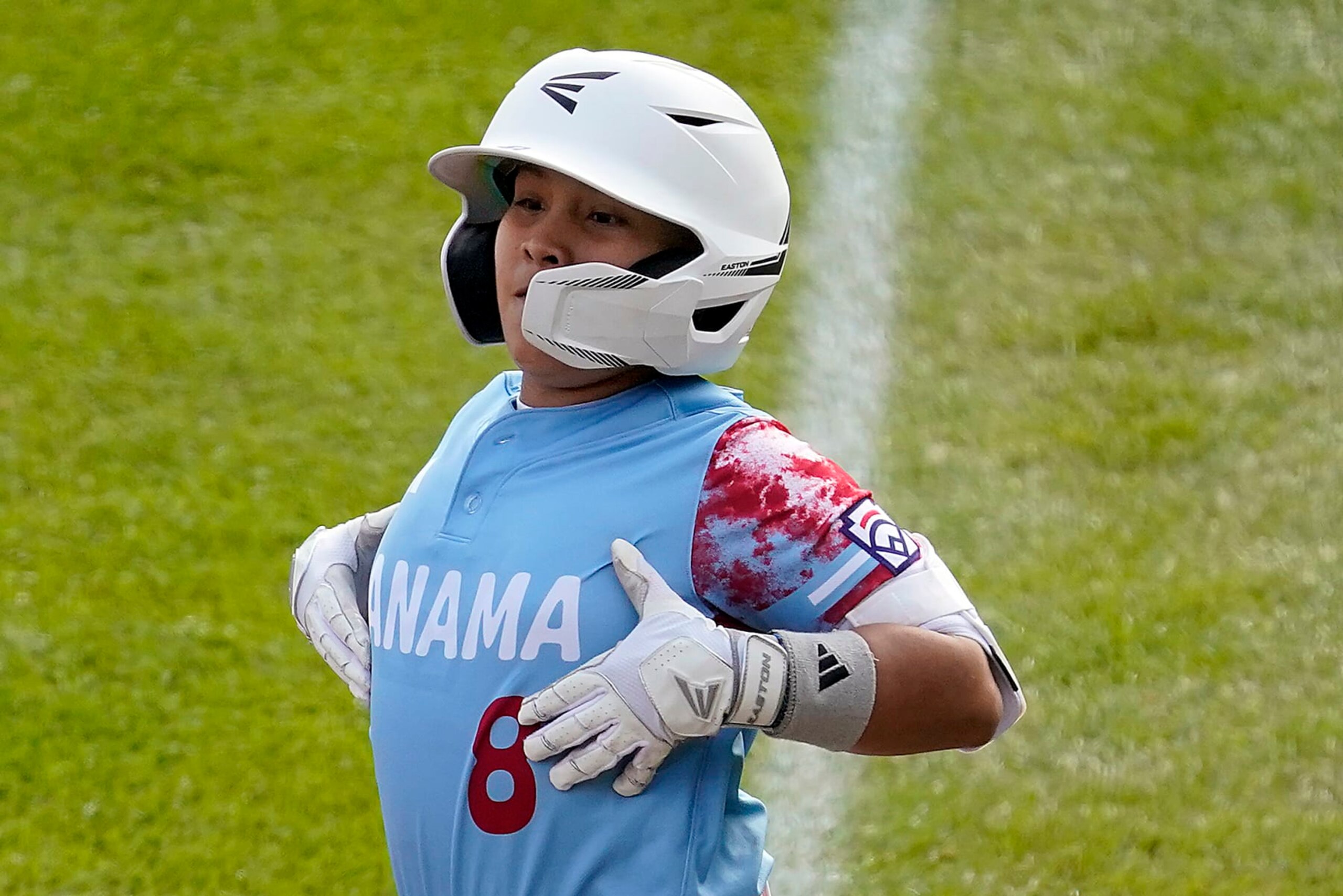 Panama's Ian Corrales (8) celebrates on first base after driving in a run against Cuba during the first inning of a baseball game at the Little League World Series tournament in South Williamsport, Pa., Sunday, Aug. 20, 2023. (AP Photo/Tom E. Puskar)