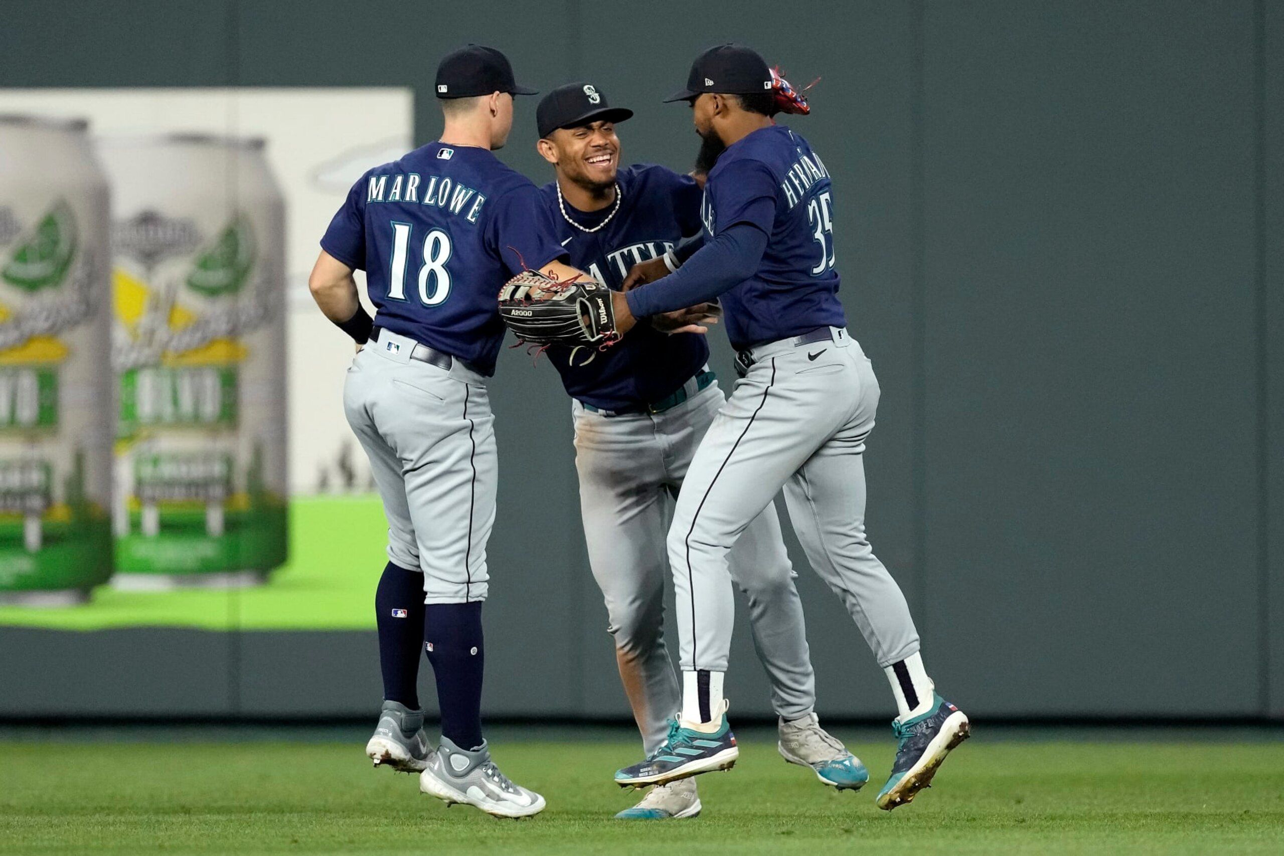 Seattle Mariners' Cade Marlowe (18), Teoscar Hernandez (35) and Julio Rodriguez, center, celebrate after their baseball game against the Kansas City Royals Wednesday, Aug. 16, 2023, in Kansas City, Mo. The Seattle Mariners won 6-5. (AP Photo/Charlie Riedel)
