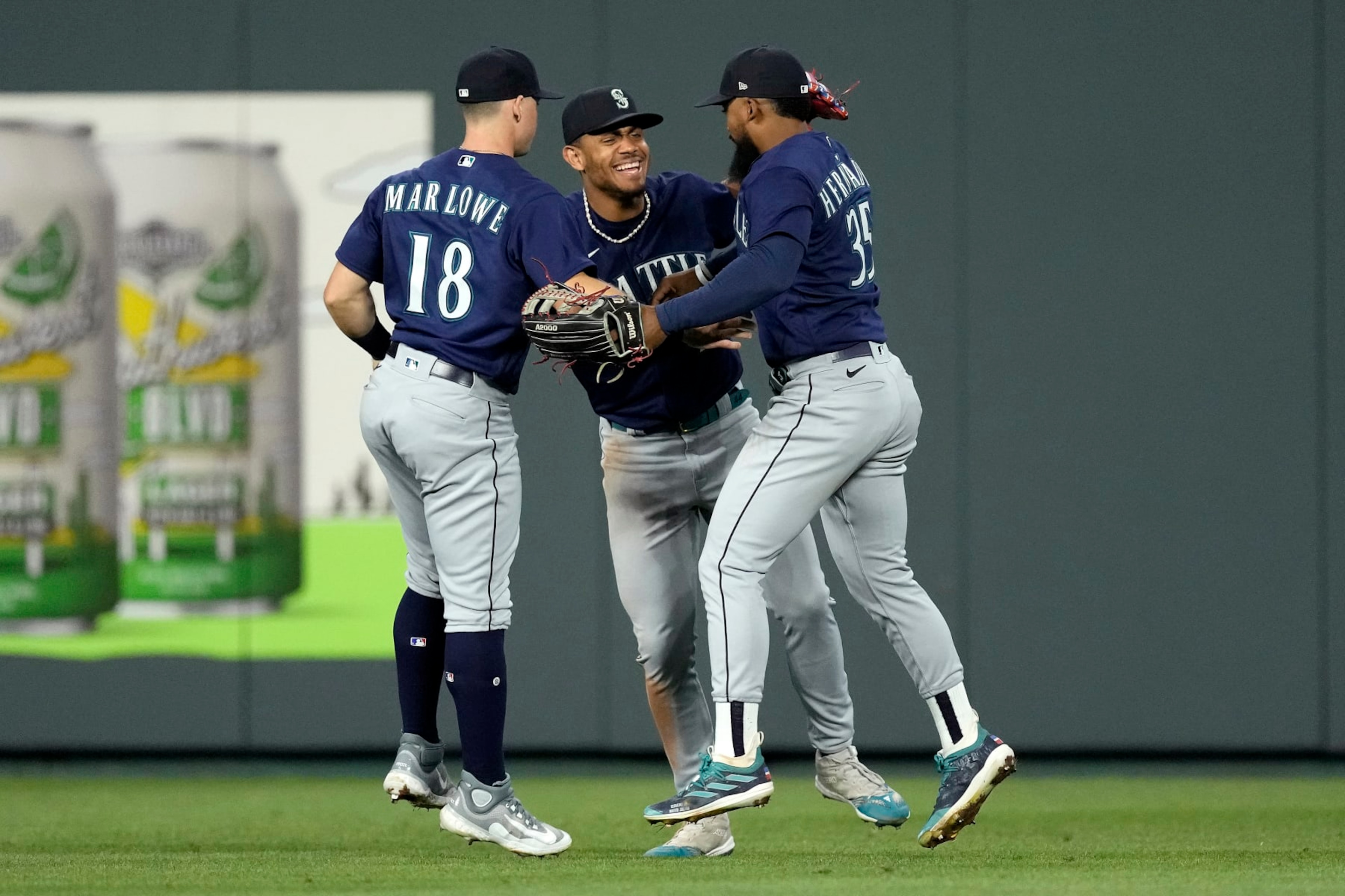 Seattle Mariners' Cade Marlowe (18), Teoscar Hernandez (35) and Julio Rodriguez, center, celebrate after their baseball game against the Kansas City Royals Wednesday, Aug. 16, 2023, in Kansas City, Mo. The Seattle Mariners won 6-5. (AP Photo/Charlie Riedel)