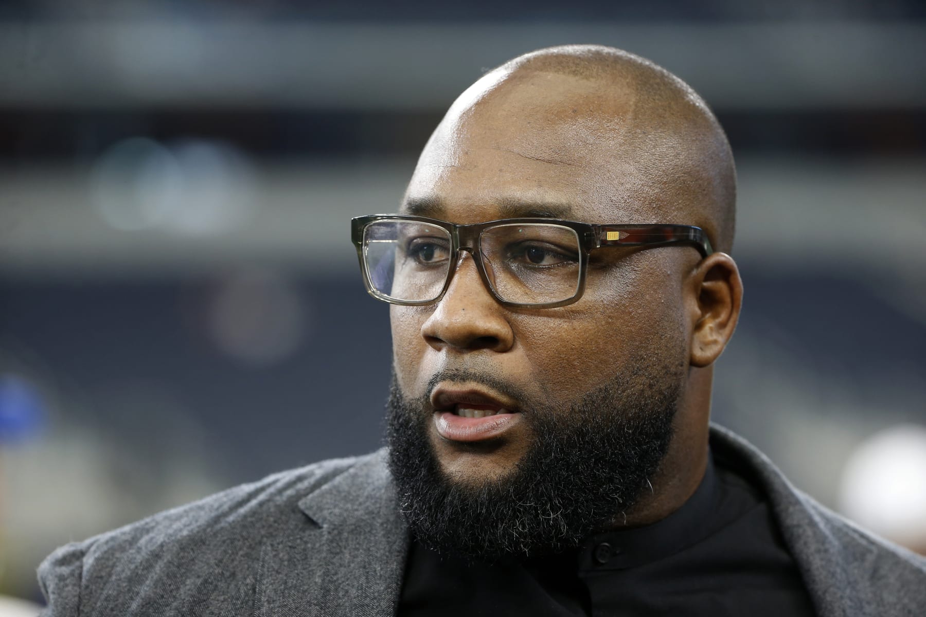 Former Dallas Cowboys player Marcus Spears stands on the field during warmups before a preseason NFL football game against the Tampa Bay Buccaneers in Arlington, Texas, Thursday, Aug. 29, 2019. (AP Photo/Ron Jenkins)