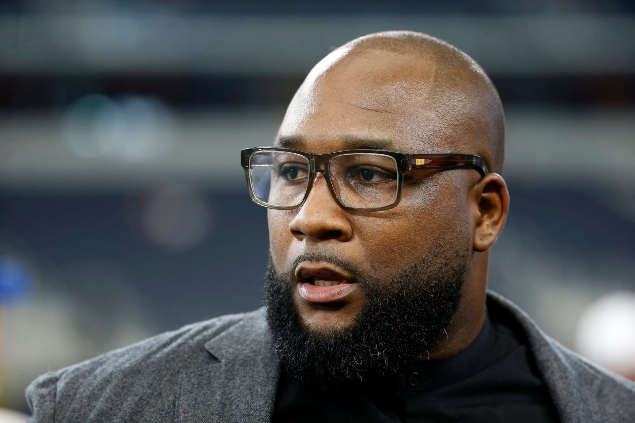 Former Dallas Cowboys player Marcus Spears stands on the field during warmups before a preseason NFL football game against the Tampa Bay Buccaneers in Arlington, Texas, Thursday, Aug. 29, 2019. (AP Photo/Ron Jenkins)