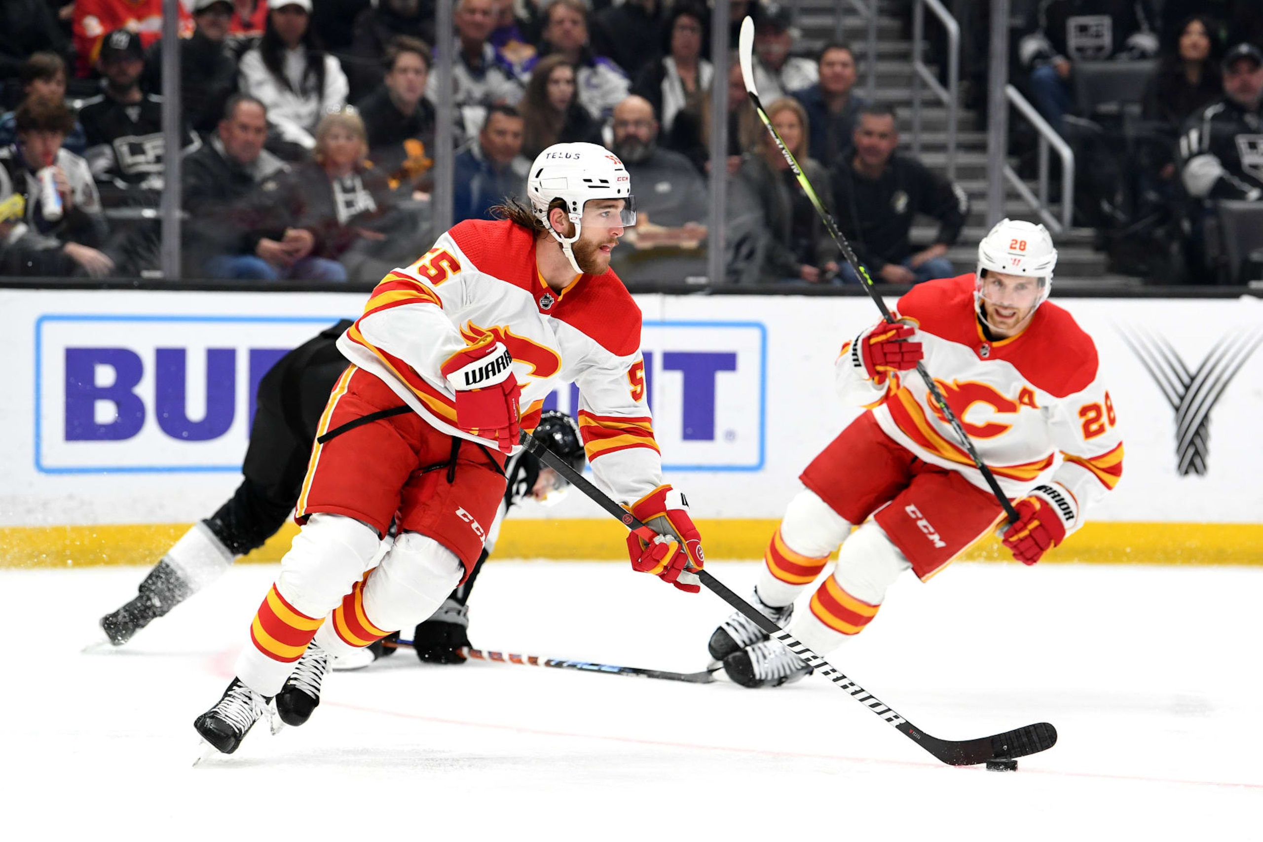 LOS ANGELES, CA - MARCH 20: Calgary Flames Defenceman Noah Hanifin (55) carries the puck as Calgary Flames Center Elias Lindholm (28) turns towards the play during an NHL hockey game between the Calgary Flames and the Los Angeles Kings on March 20th, 2023, at the Crypto.com Arena in Los Angeles, CA. (Photo by Rob Curtis/Icon Sportswire via Getty Images)