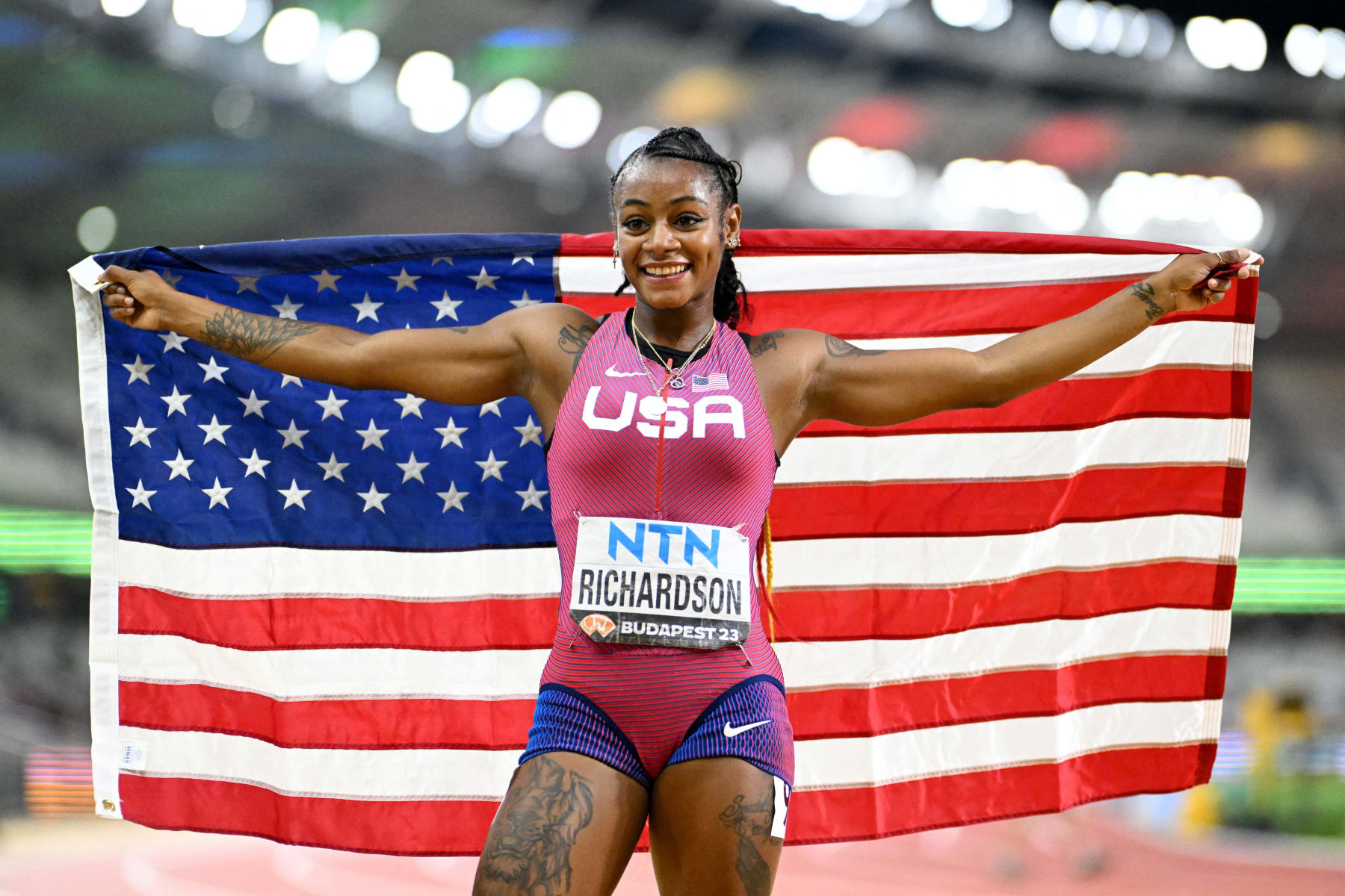USA's Sha'Carri Richardson celebrates with a US flag after winning the women's 100m final during the World Athletics Championships at the National Athletics Centre in Budapest on August 21, 2023. (Photo by Jewel SAMAD / AFP) (Photo by JEWEL SAMAD/AFP via Getty Images)