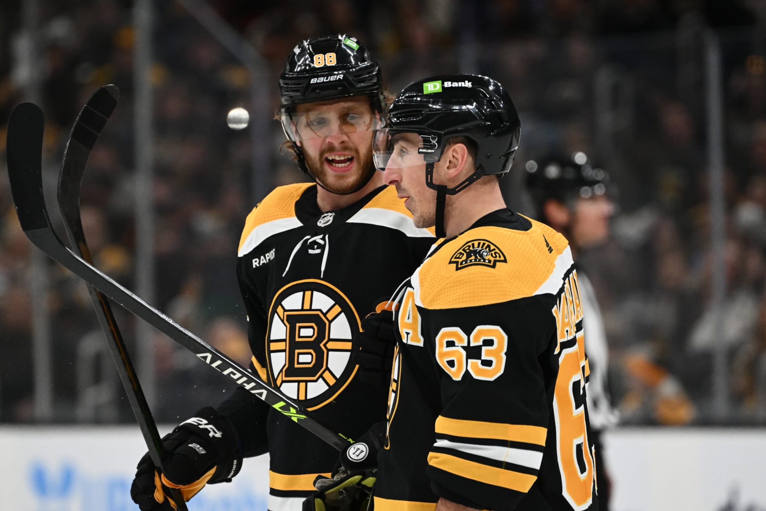 BOSTON, MASSACHUSETTS - MARCH 21: David Pastrnak #88 of the Boston Bruins talks with Brad Marchand #63 during the first period of a game against the Ottawa Senators at the TD Garden on March 21, 2023 in Boston, Massachusetts. (Photo by Brian Fluharty/Getty Images)