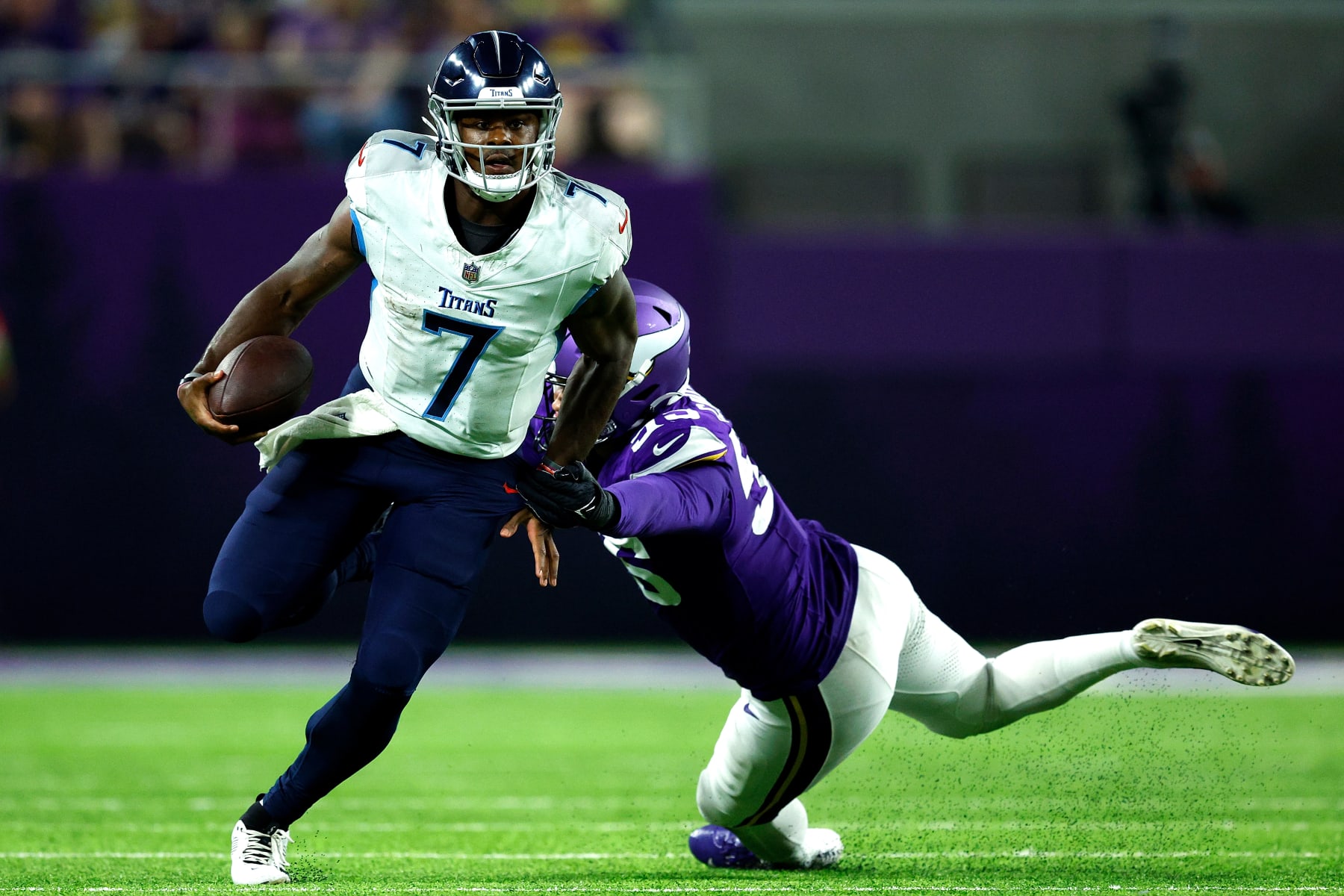 MINNEAPOLIS, MINNESOTA - AUGUST 19: Malik Willis #7 of the Tennessee Titans avoids a tackle by Andre Carter II #55 of the Minnesota Vikings in the second half during a preseason game at U.S. Bank Stadium on August 19, 2023 in Minneapolis, Minnesota. The Titans defeated the Vikings 24-16. (Photo by David Berding/Getty Images)