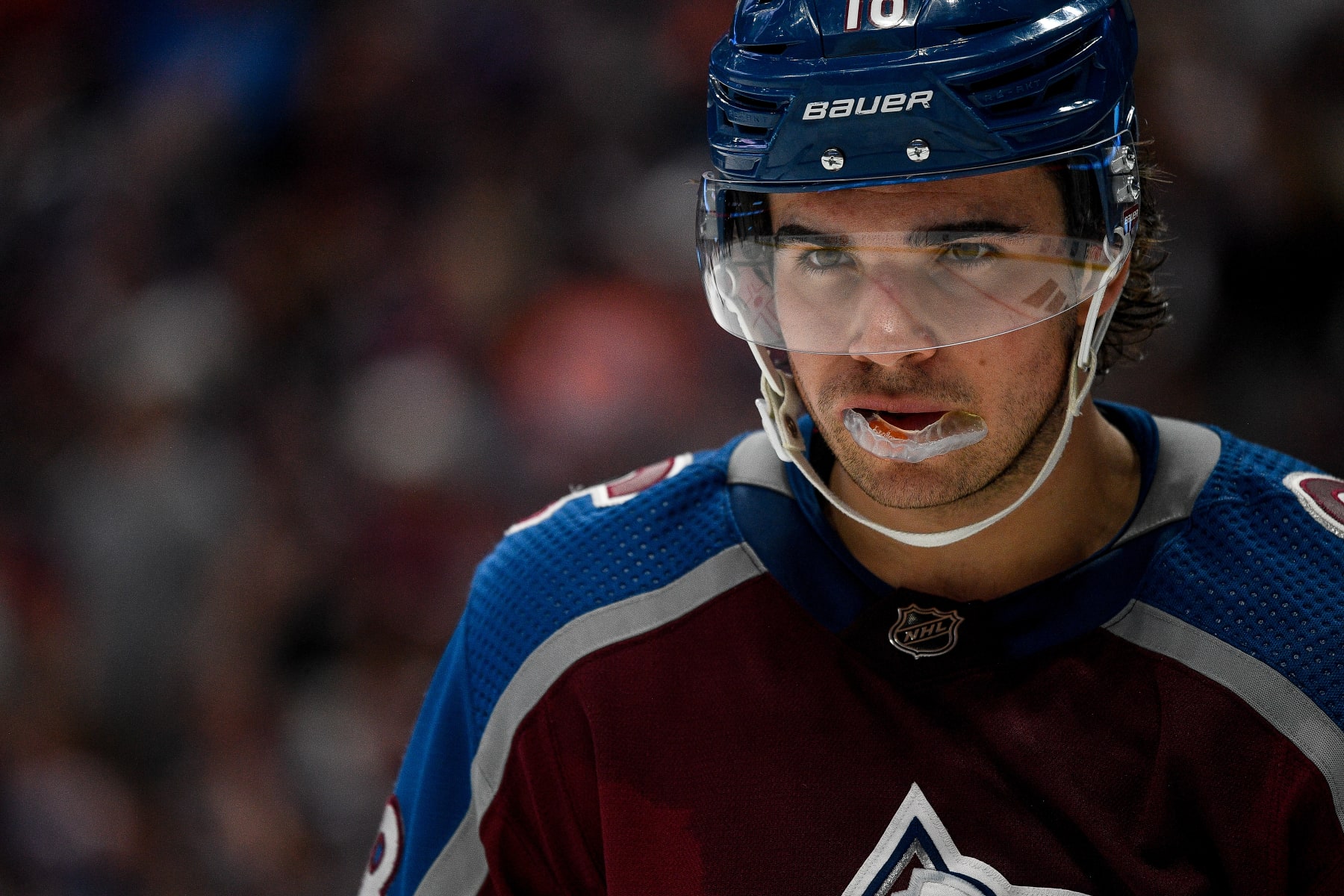 DENVER, COLORADO - APRIL 11:  Alex Newhook #18 of the Colorado Avalanche looks on in the second period of a game against the Edmonton Oilers at Ball Arena on April 11, 2023 in Denver, Colorado. (Photo by Dustin Bradford/Getty Images)