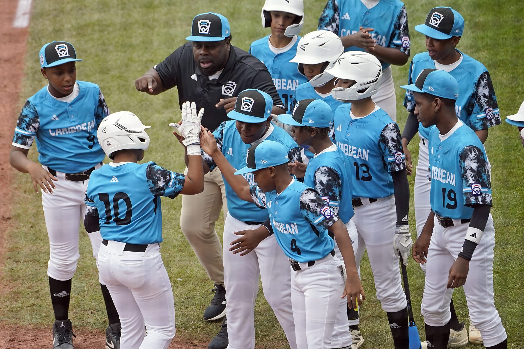 Curacao's Jay-Dlynn Wiel (10) celebrates with his teammates on the way back to the dugout after his home run off of Taiwan starting pitcher Cai Yuan-Hao during the first inning of a baseball game at the Little League World Series tournament in South Williamsport, Pa., Wednesday, Aug. 23, 2023. (AP Photo/Tom E. Puskar)
