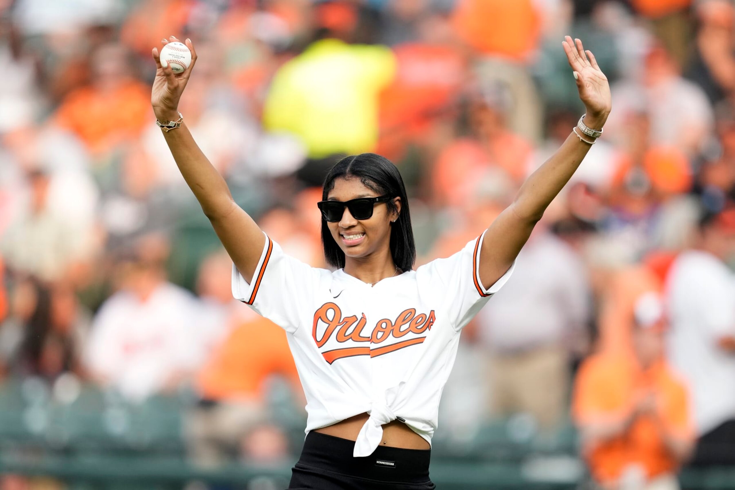 BALTIMORE, MD - JULY 18: LSU basketball star Angel Reese waves to the fans before throwing out the ceremonial first pitch at a baseball game between the Baltimore Orioles and the Los Angeles Dodgers at Oriole Park at Camden Yards on July 18, 2023 in Baltimore, Maryland. (Photo by Mitchell Layton/Getty Images)