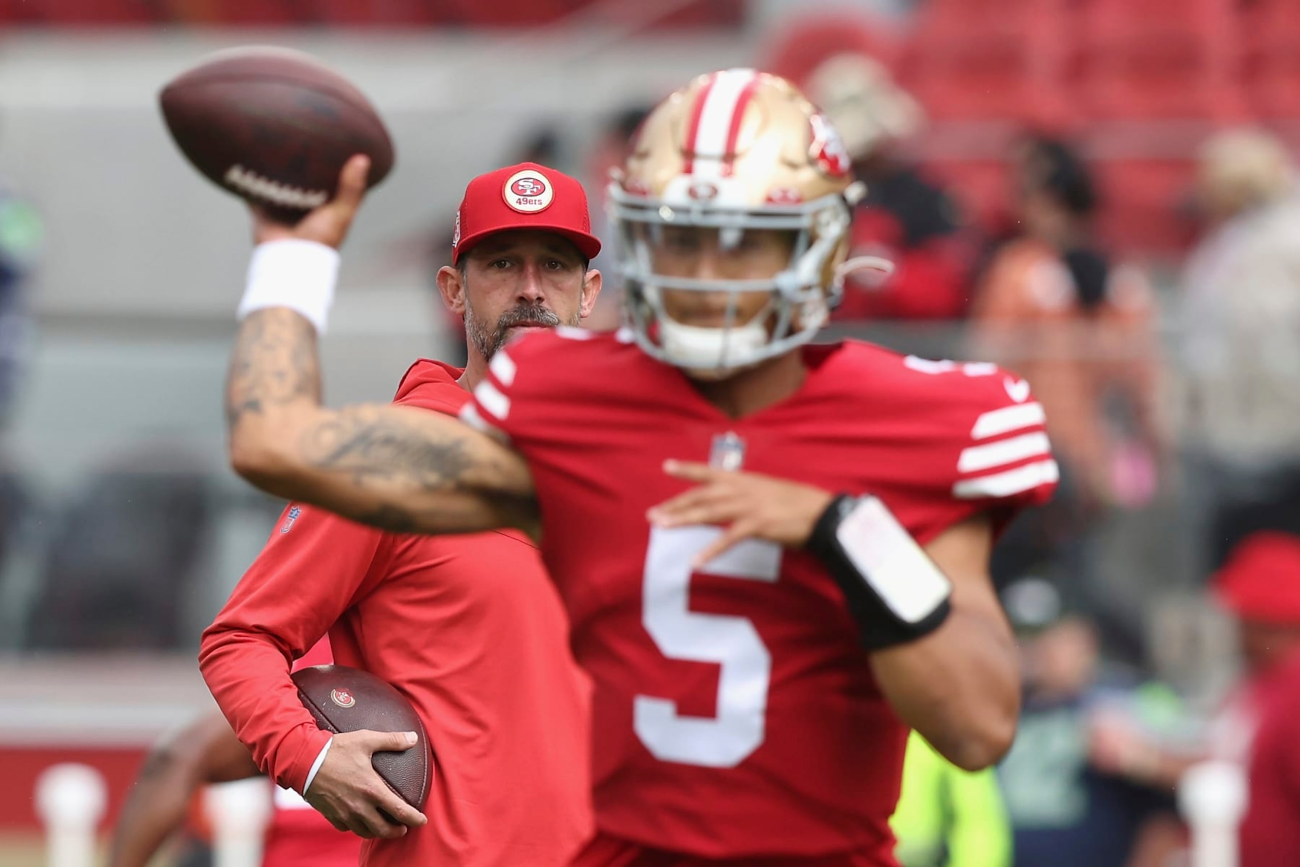 San Francisco 49ers head coach Kyle Shanahan looks on as San Francisco 49ers quarterback Trey Lance (5) warms up before an NFL football game against the Seattle Seahawks, Sunday, Sept. 18, 2022 in Santa Clara, Calif. (AP Photo/Lachlan Cunningham)