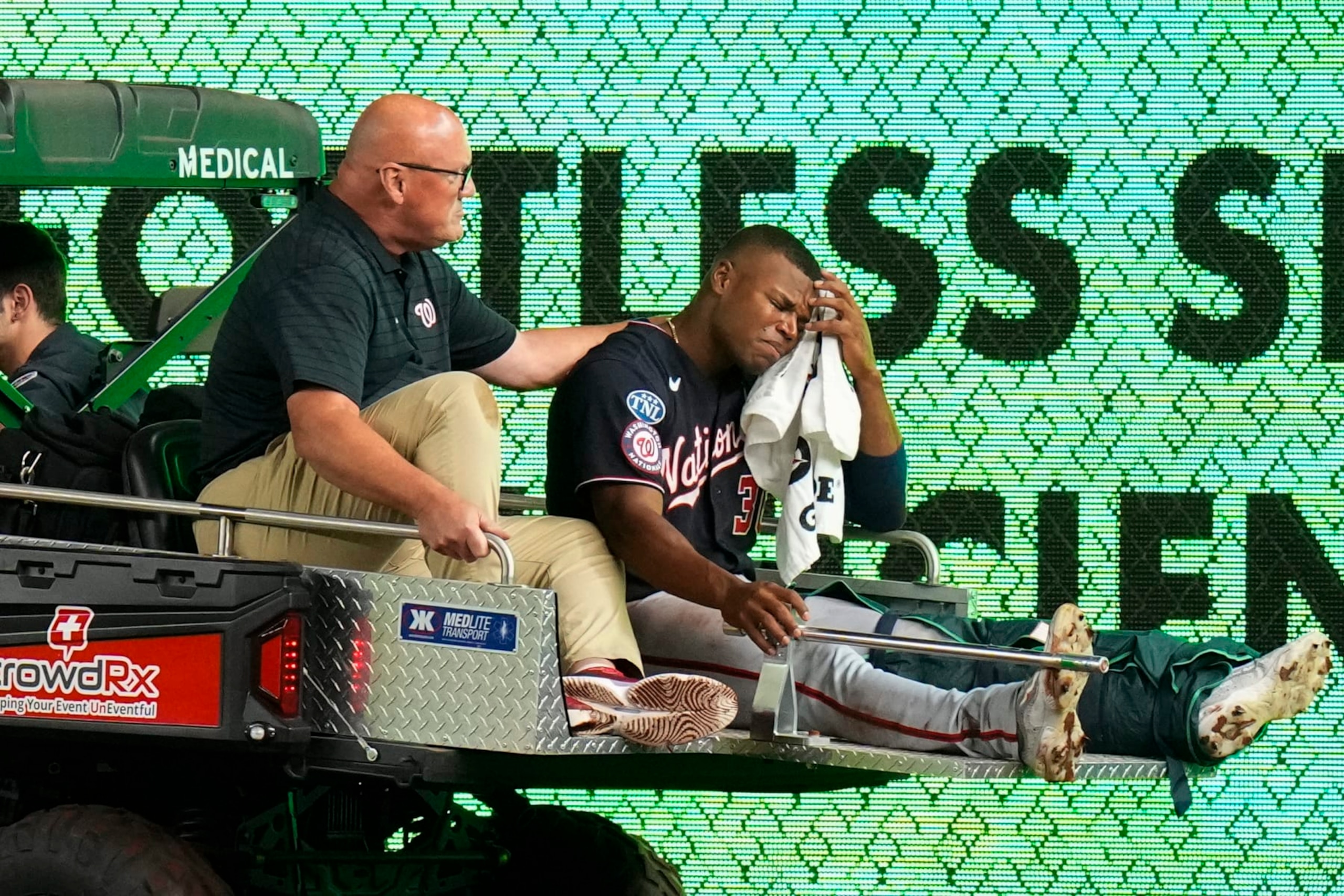 A trainer comforts Washington Nationals left fielder Stone Garrett, who is carted off the field after being injured during the seventh inning of the team's baseball game against the New York Yankees on Wednesday, Aug. 23, 2023, in New York. (AP Photo/Frank Franklin II)