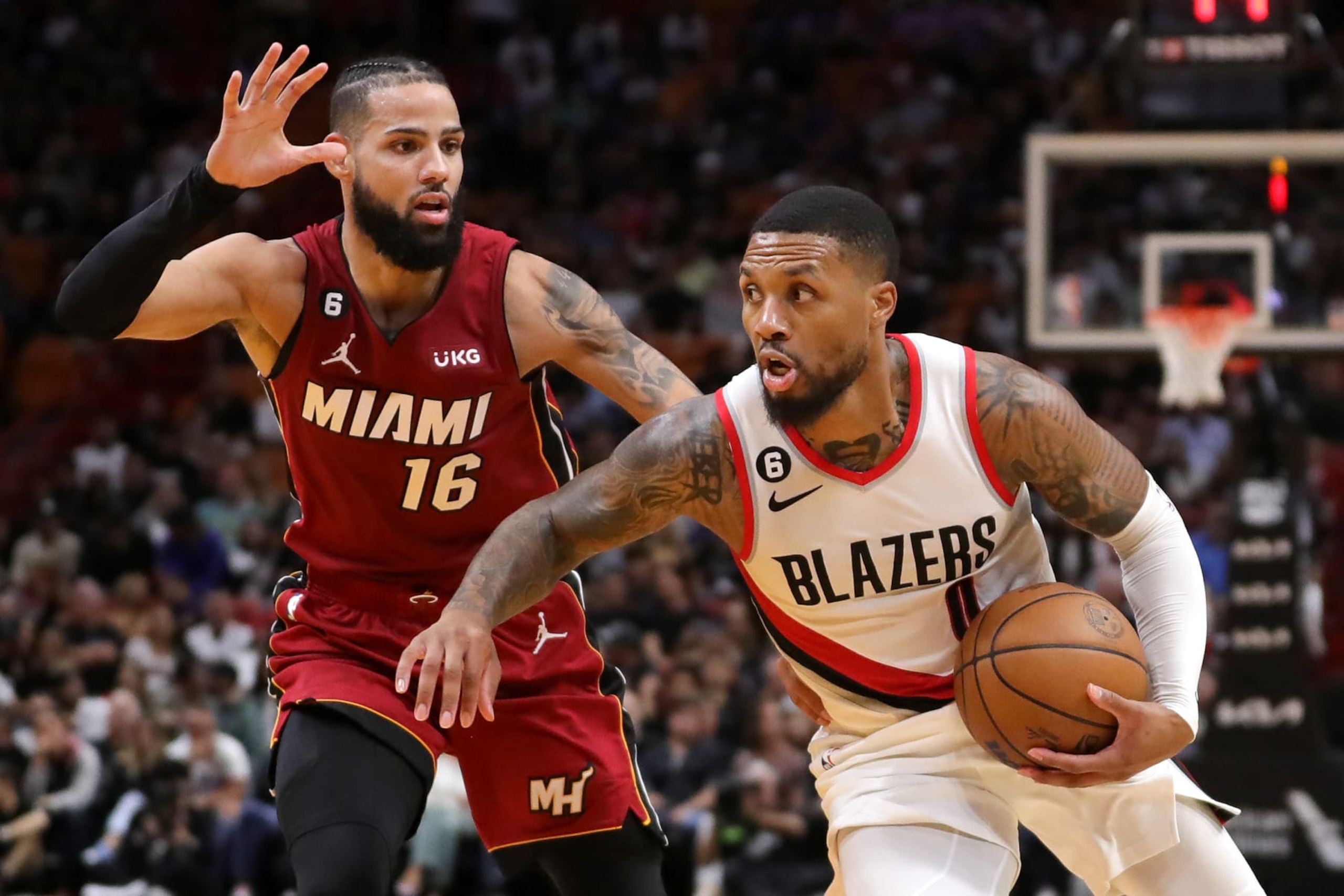 MIAMI, FLORIDA - NOVEMBER 07: Damian Lillard #0 of the Portland Trail Blazers drives past Caleb Martin #16 of the Miami Heat during the second quarter at FTX Arena on November 07, 2022 in Miami, Florida. NOTE TO USER: User expressly acknowledges and agrees that, by downloading and or using this photograph, User is consenting to the terms and conditions of the Getty Images License Agreement. (Photo by Megan Briggs/Getty Images)
