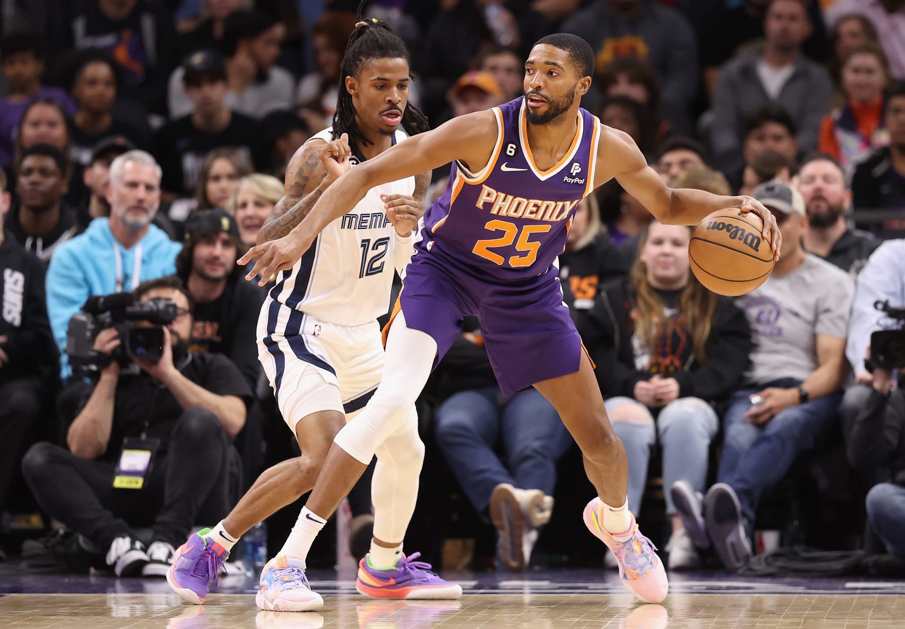 PHOENIX, ARIZONA - JANUARY 22: Mikal Bridges #25 of the Phoenix Suns handles the ball against Ja Morant #12 of the Memphis Grizzliesduring the second half of the NBA game at Footprint Center on January 22, 2023 in Phoenix, Arizona.  The Suns defeated the Grizzlies 112-110. NOTE TO USER: User expressly acknowledges and agrees that, by downloading and or using this photograph, User is consenting to the terms and conditions of the Getty Images License Agreement. (Photo by Christian Petersen/Getty Images)