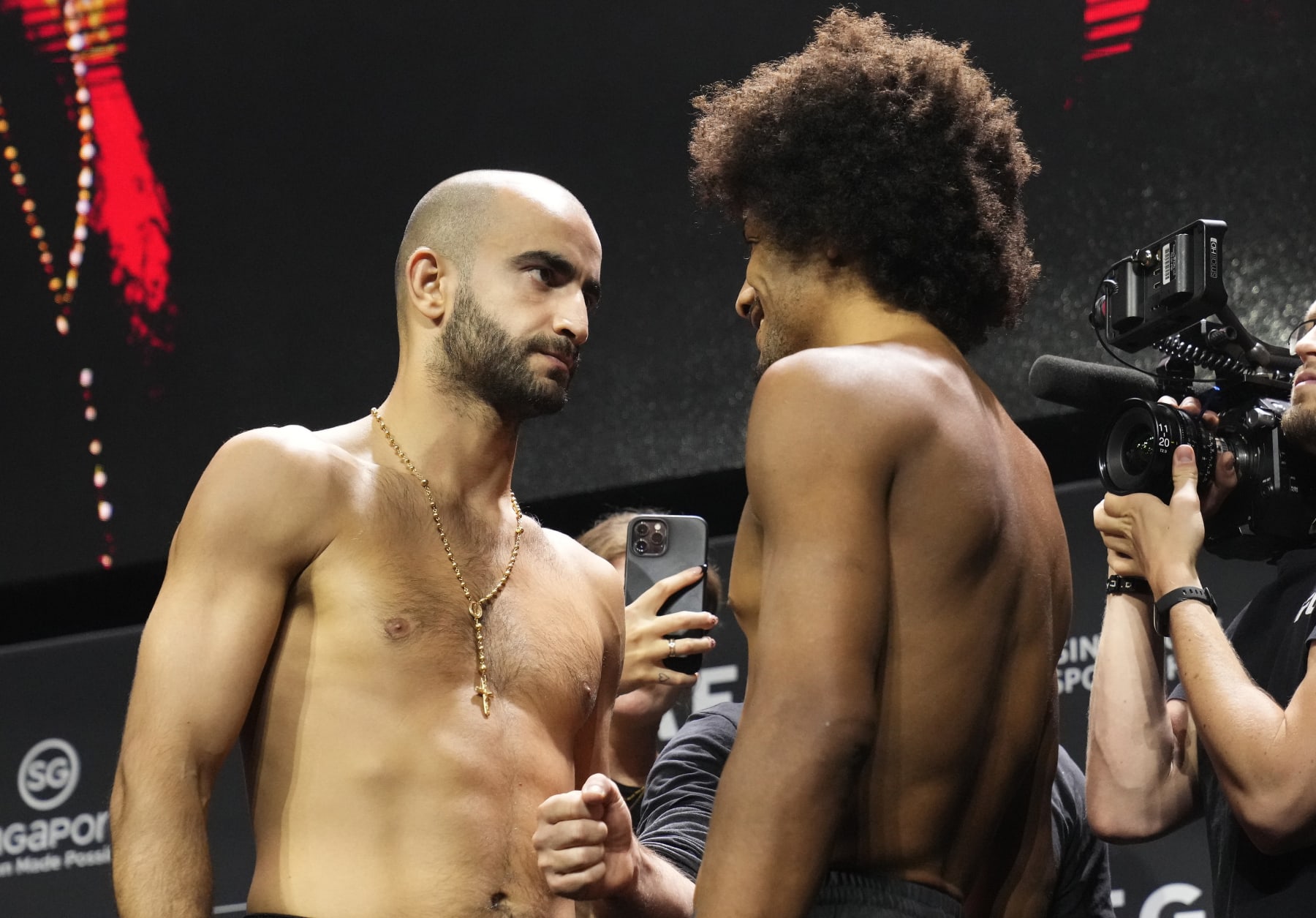 SINGAPORE, SINGAPORE - AUGUST 25: (L-R) Opponents Giga Chikadze of Georgia and Alex Caceres face off during the UFC Fight Night ceremonial weigh-in at Singapore Indoor Stadium on August 25, 2023 in Singapore. (Photo by Mike Roach/Zuffa LLC via Getty Images)