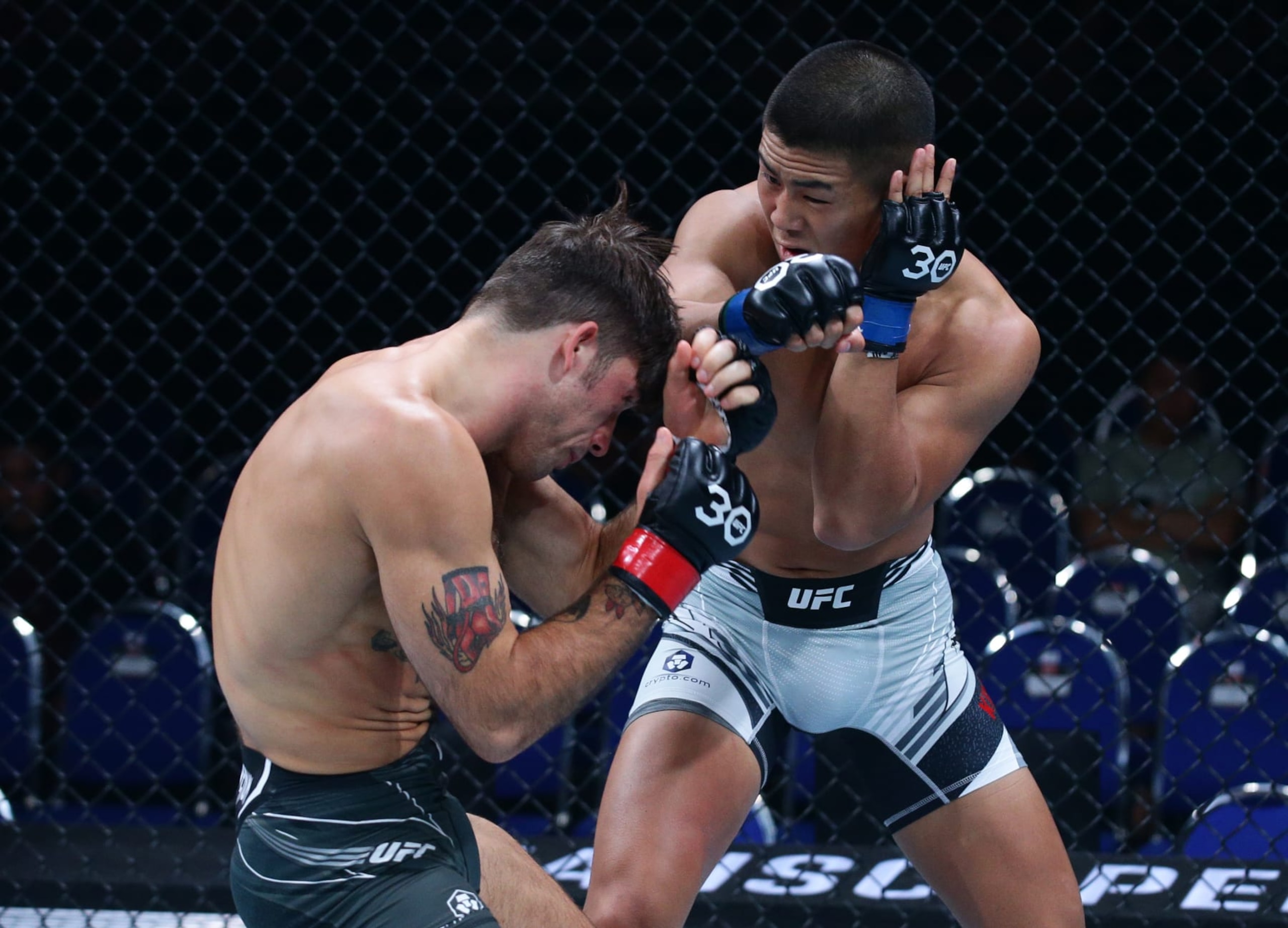 SINGAPORE, SINGAPORE - AUGUST 26: (R-L) Yusaku Kinoshita of Japan punches Billy Goff in a welterweight bout during the UFC Fight Night event at Singapore Indoor Stadium on August 26, 2023 in Singapore. (Photo by Suhaimi Abdullah/Zuffa LLC via Getty Images)