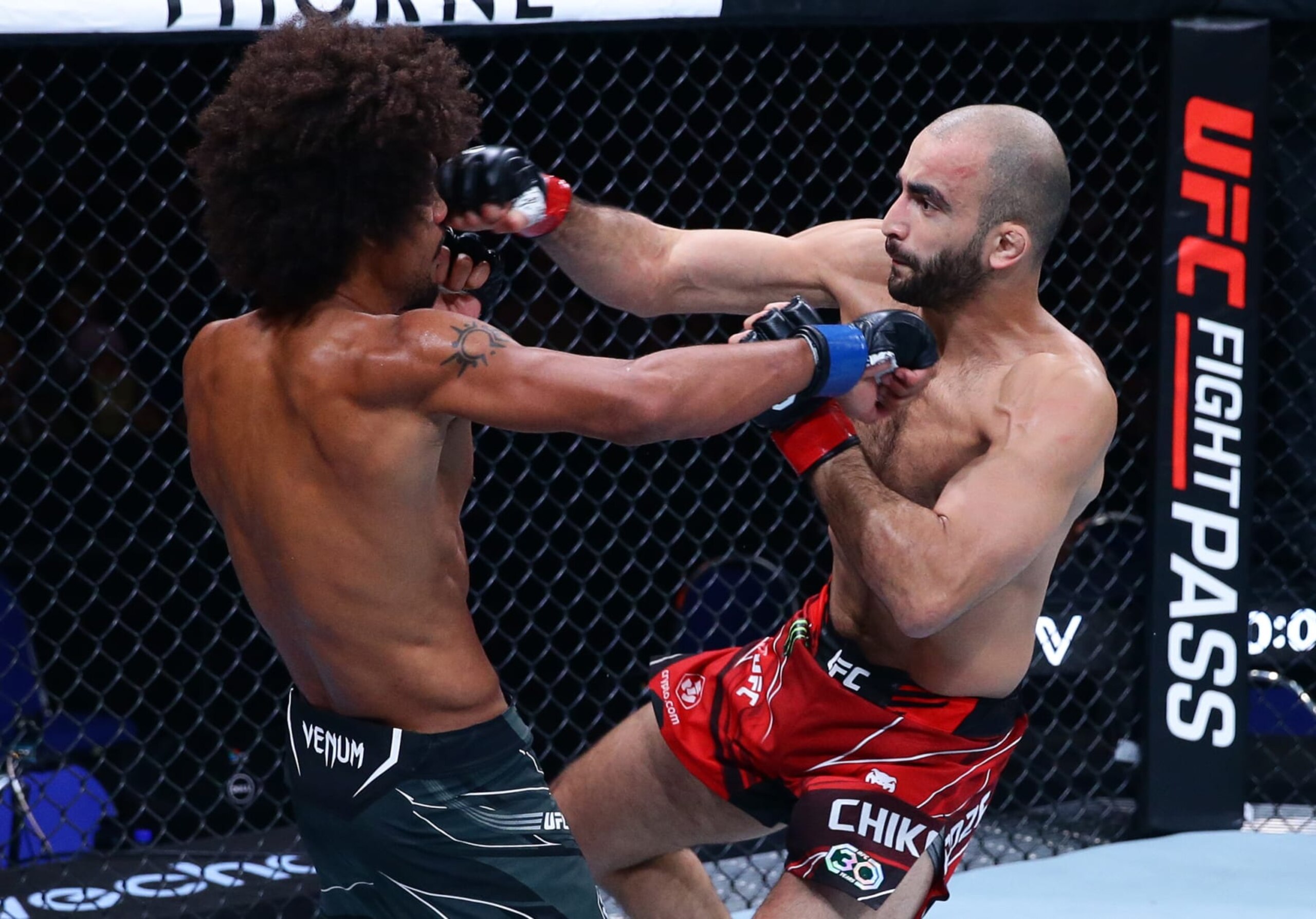 SINGAPORE, SINGAPORE - AUGUST 26: (R-L) Giga Chikadze of Georgia punches Alex Caceres in a featherweight bout during the UFC Fight Night event at Singapore Indoor Stadium on August 26, 2023 in Singapore. (Photo by Suhaimi Abdullah/Zuffa LLC via Getty Images)