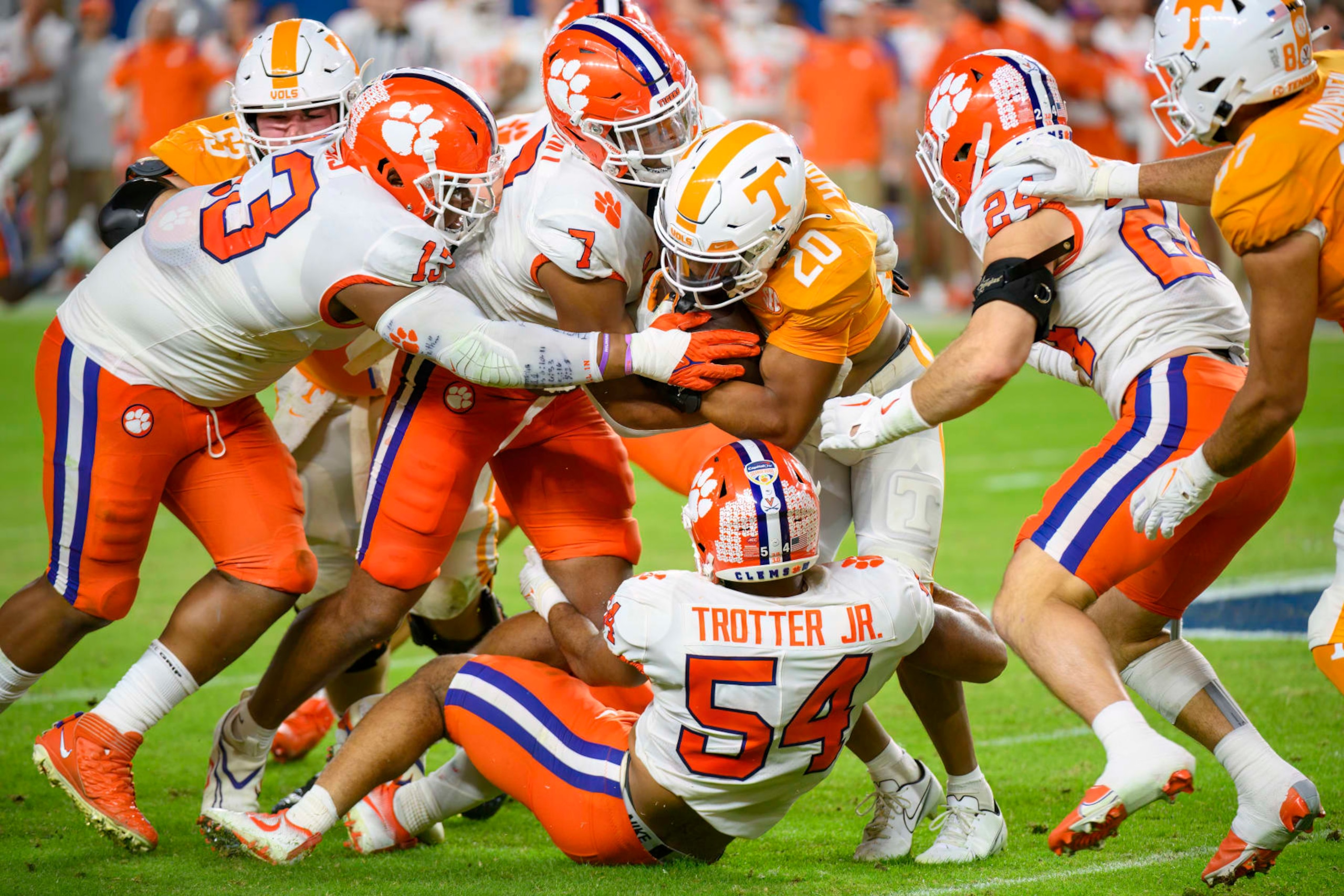 MIAMI GARDENS, FL - DECEMBER 30: Tennessee running back Jaylen Wright (20) runs with the ball and is tackled by Clemson defensive tackle Tyler Davis (13), Clemson defensive end Justin Mascoll (7), Clemson linebacker Jeremiah Trotter Jr. (54) and Clemson safety Tyler Venables (24) during the Capital One Orange Bowl college football game between the Tennessee Volunteers and the Clemson Tigers on December 30, 2022 at the Hard Rock Stadium in Miami Gardens, FL. (Photo by Doug Murray/Icon Sportswire via Getty Images)