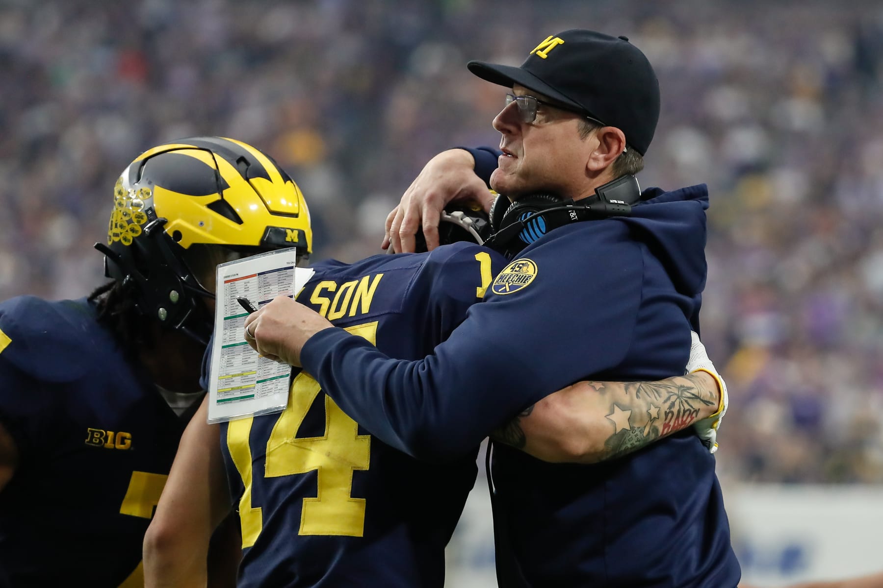 GLENDALE, AZ - DECEMBER 31:  Michigan Wolverines head coach Jim Harbaugh embraces Michigan Wolverines wide receiver Roman Wilson (14) during the VRBO Fiesta Bowl college football national championship semifinal game between the Michigan Wolverines and the TCU Horned Frogs on December 31, 2022 at State Farm Stadium in Glendale, Arizona. (Photo by Kevin Abele/Icon Sportswire via Getty Images)