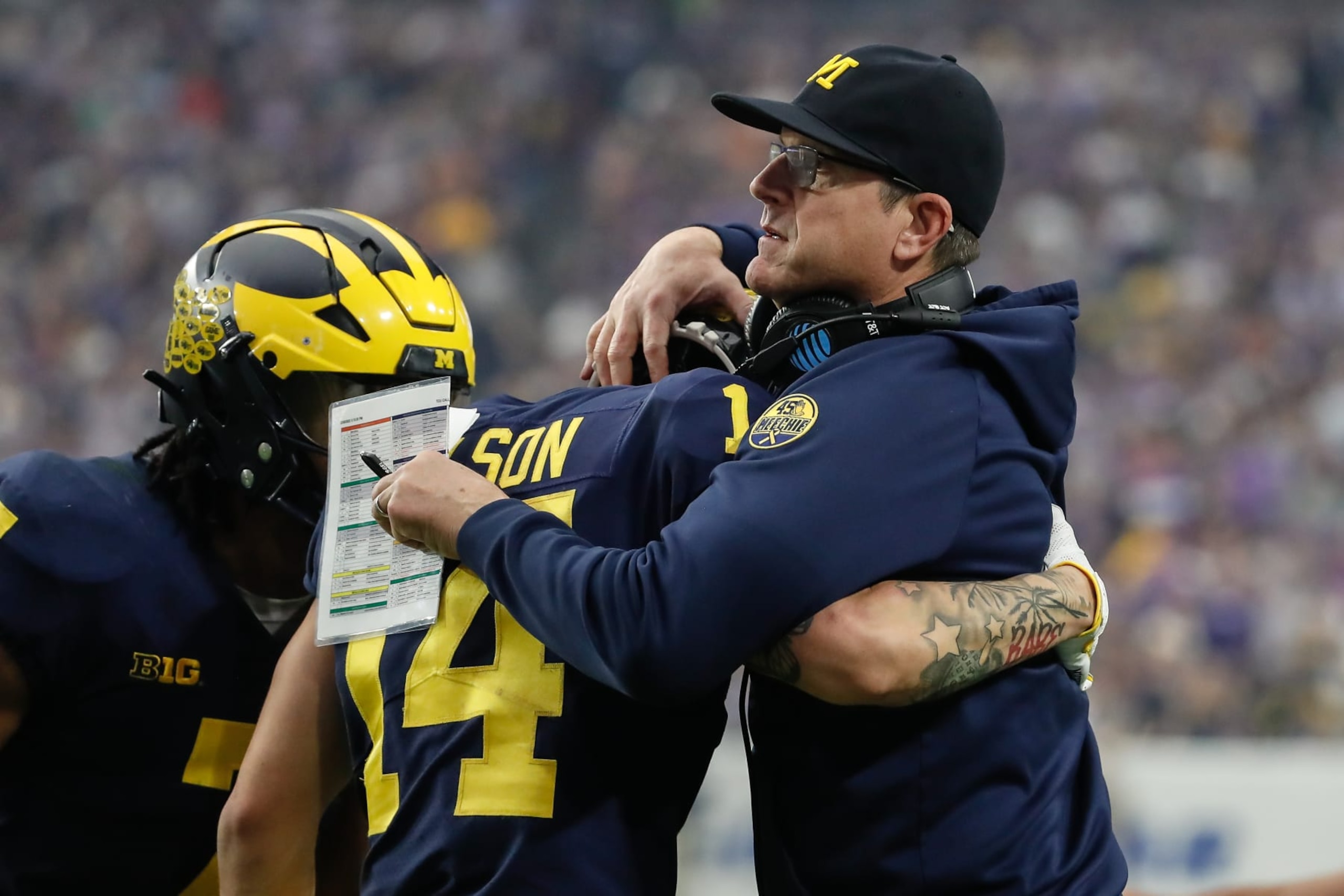 GLENDALE, AZ - DECEMBER 31:  Michigan Wolverines head coach Jim Harbaugh embraces Michigan Wolverines wide receiver Roman Wilson (14) during the VRBO Fiesta Bowl college football national championship semifinal game between the Michigan Wolverines and the TCU Horned Frogs on December 31, 2022 at State Farm Stadium in Glendale, Arizona. (Photo by Kevin Abele/Icon Sportswire via Getty Images)
