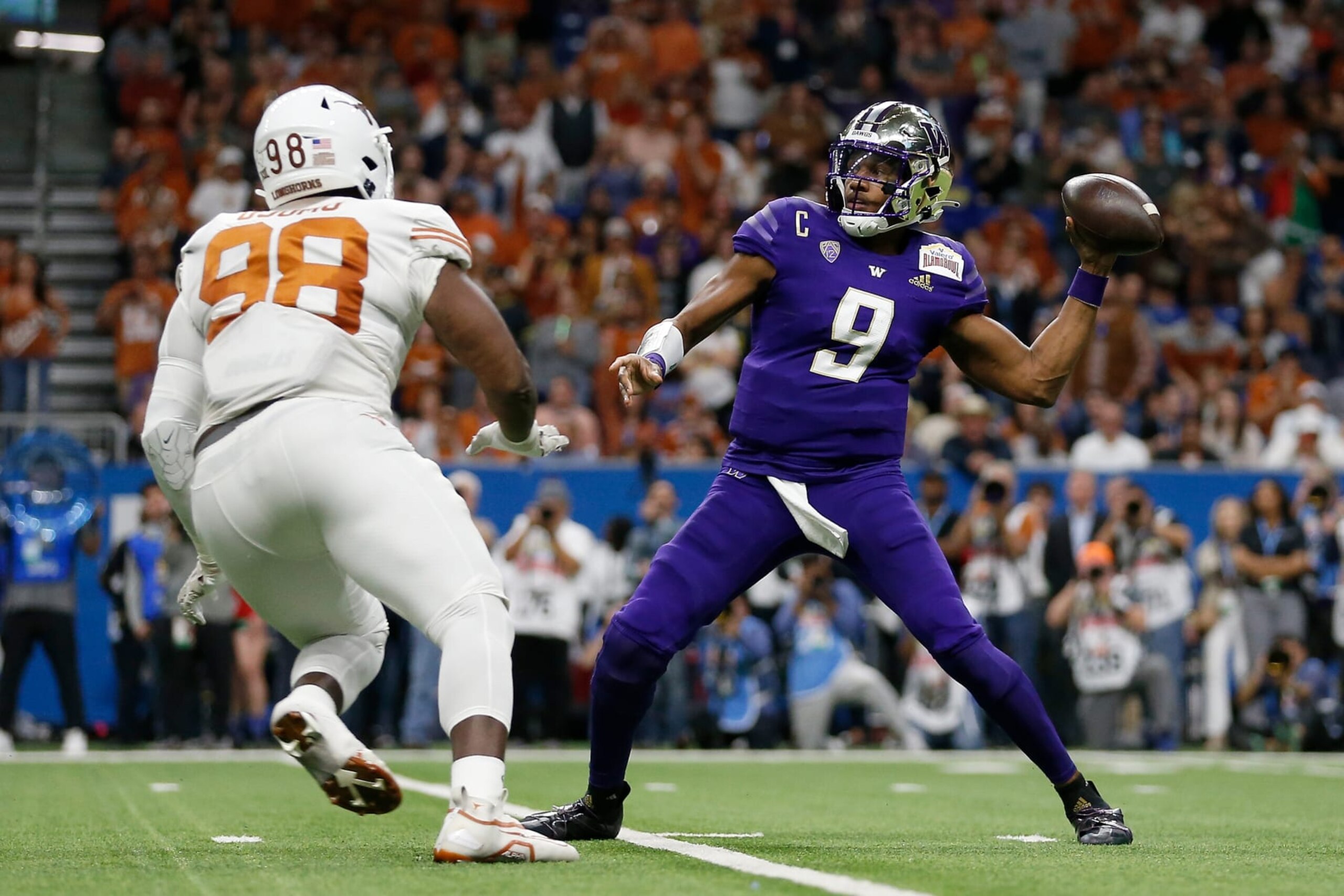 SAN ANTONIO, TEXAS - DECEMBER 29: Michael Penix Jr. #9 of the Washington Huskies throws a pass under pressure by Moro Ojomo #98 of the Texas Longhorns in the first quarter during the Valero Alamo Bowl at Alamodome on December 29, 2022 in San Antonio, Texas. (Photo by Tim Warner/Getty Images)