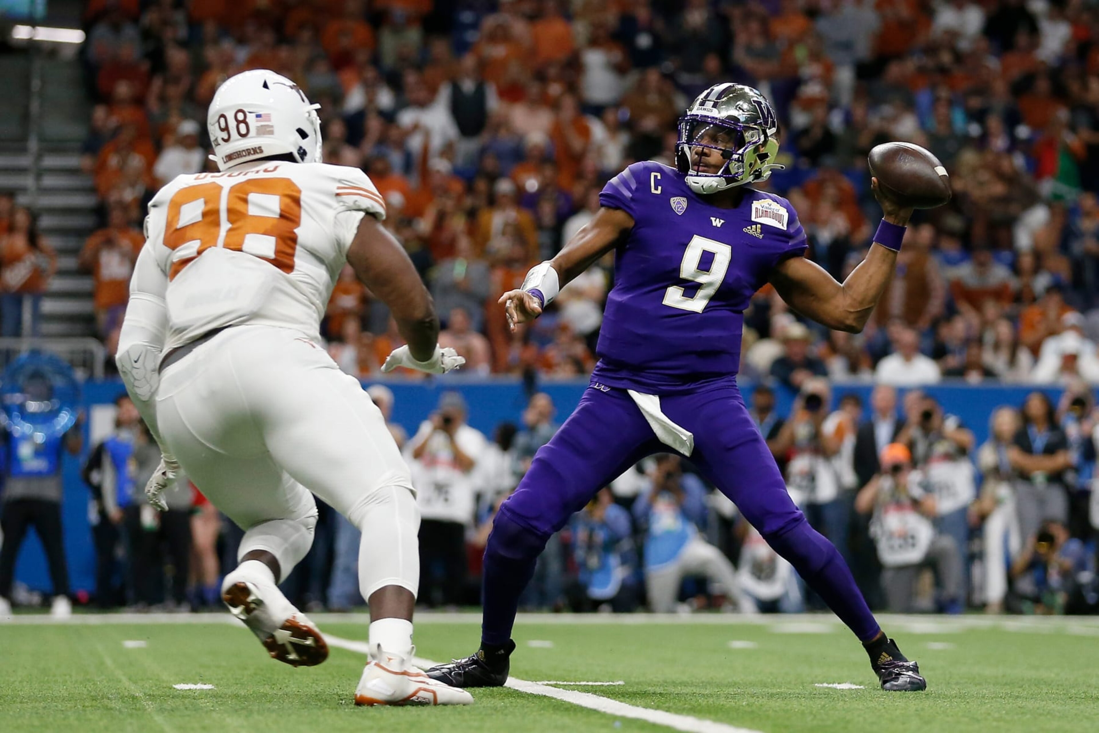 SAN ANTONIO, TEXAS - DECEMBER 29: Michael Penix Jr. #9 of the Washington Huskies throws a pass under pressure by Moro Ojomo #98 of the Texas Longhorns in the first quarter during the Valero Alamo Bowl at Alamodome on December 29, 2022 in San Antonio, Texas. (Photo by Tim Warner/Getty Images)