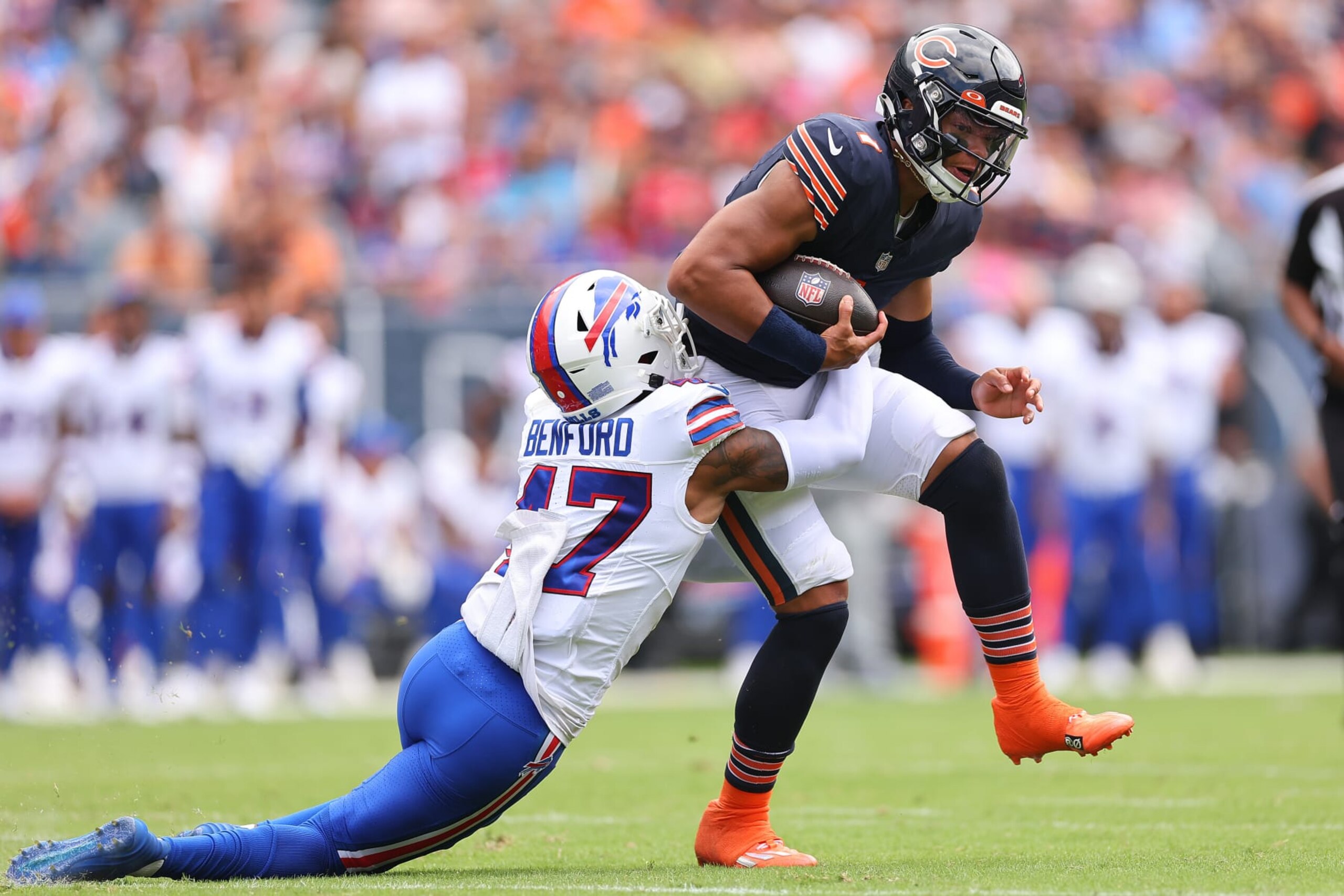 CHICAGO, ILLINOIS - AUGUST 26: Justin Fields #1 of the Chicago Bears is tackled by Christian Benford #47 of the Buffalo Bills during the first half of a preseason game at Soldier Field on August 26, 2023 in Chicago, Illinois. (Photo by Michael Reaves/Getty Images)