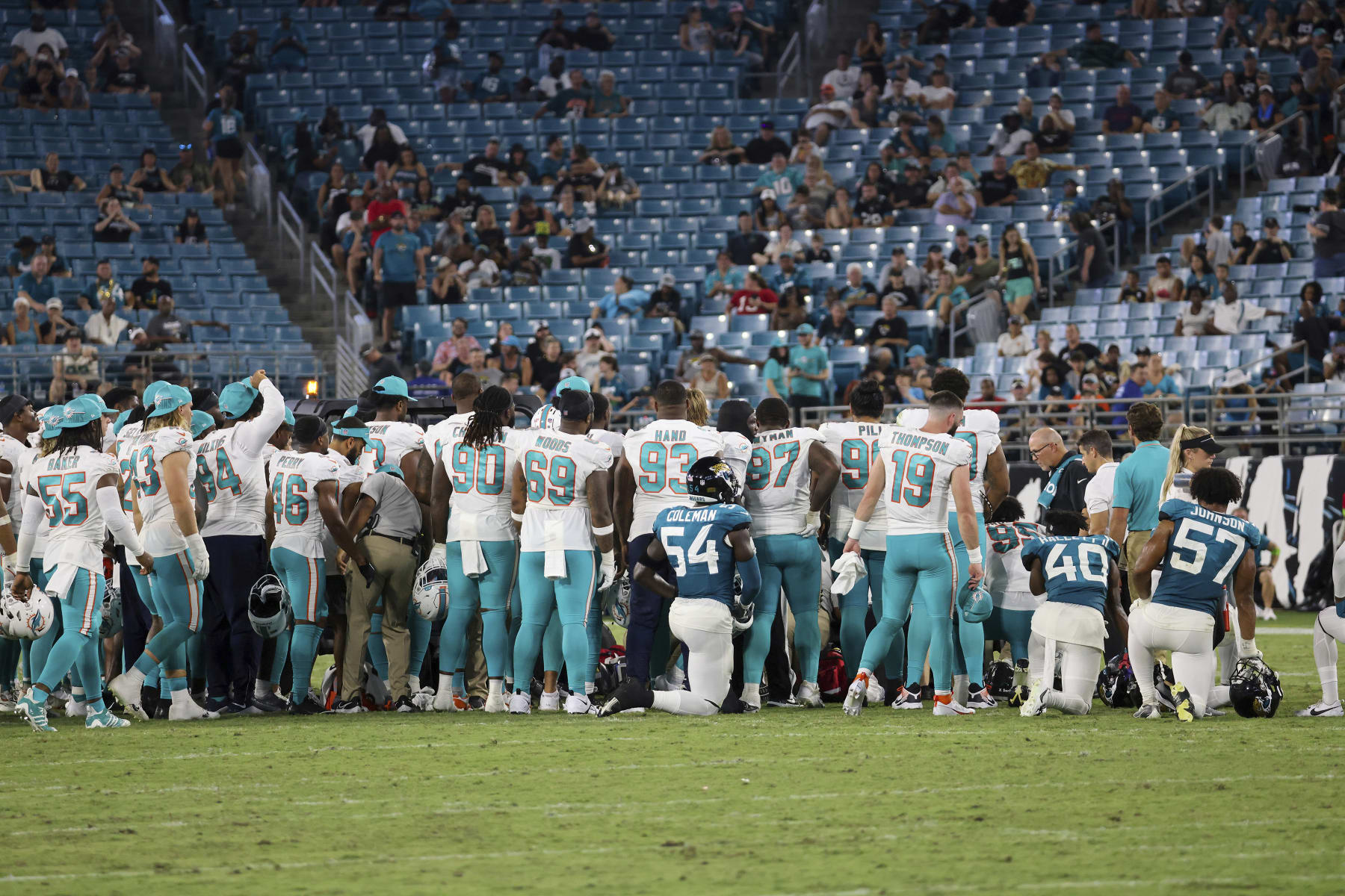 Players gather on the field after an injury to Miami Dolphins wide receiver Daewood Davis during the second half of an NFL preseason football game against the Jacksonville Jaguars, Saturday, Aug. 26, 2023, in Jacksonville, Fla. (AP Photo/Alex Menendez)