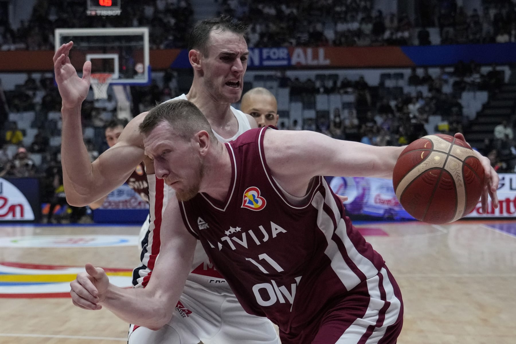 Latvia forward Rolands Smits (11) drives against France forward Terry Tarpey (22) during the Basketball World Cup group H match between France and Latvia at the Indonesia Arena stadium in Jakarta, Indonesia, Sunday, Aug. 27, 2023. (AP Photo/Achmad Ibrahim)