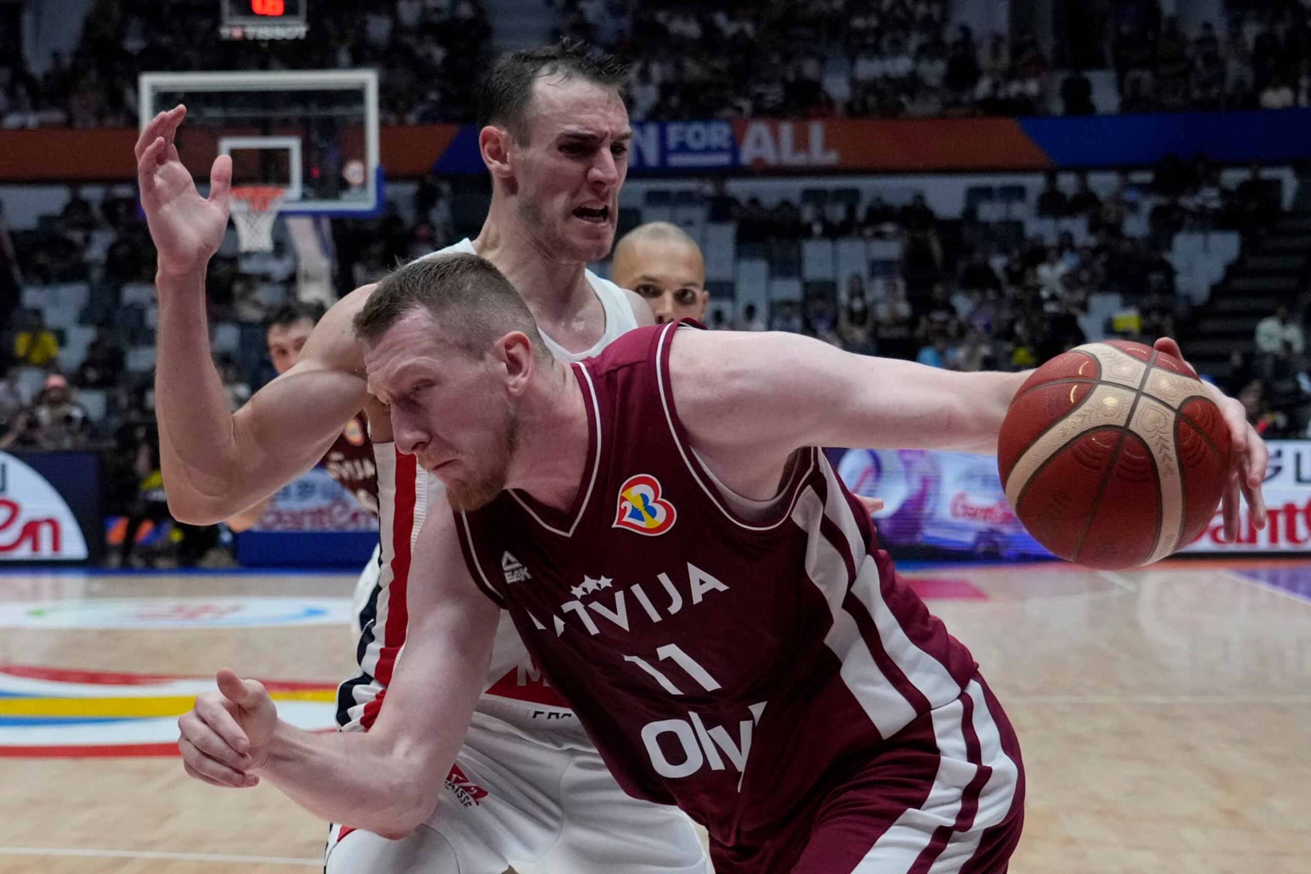 Latvia forward Rolands Smits (11) drives against France forward Terry Tarpey (22) during the Basketball World Cup group H match between France and Latvia at the Indonesia Arena stadium in Jakarta, Indonesia, Sunday, Aug. 27, 2023. (AP Photo/Achmad Ibrahim)